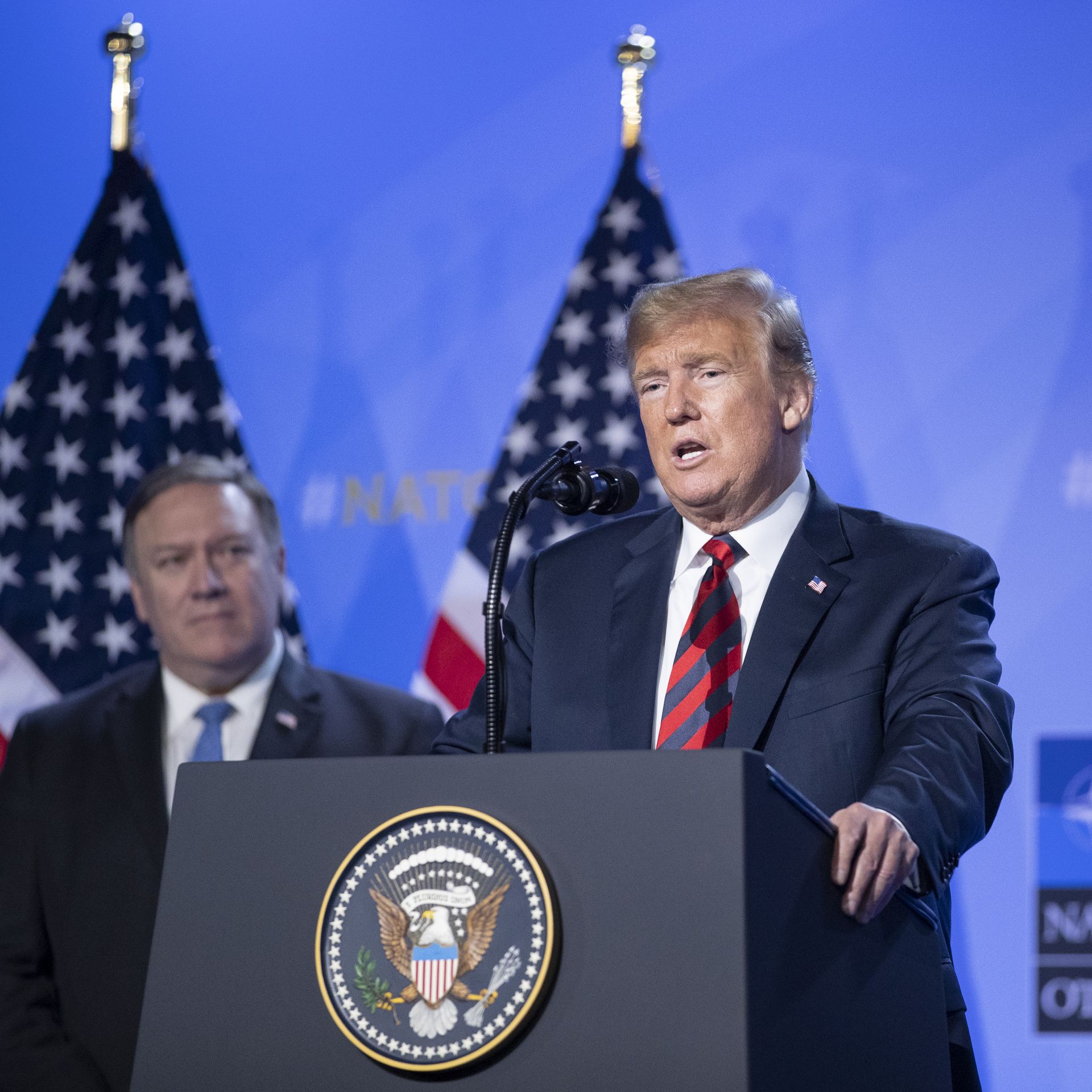 President Donald Trump speaks besides U.S. Secretary of State Mike Pompeo during a news conference at the 2018 NATO Summit.