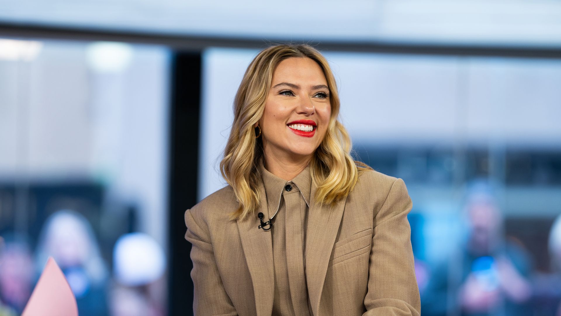A woman in a beige suit