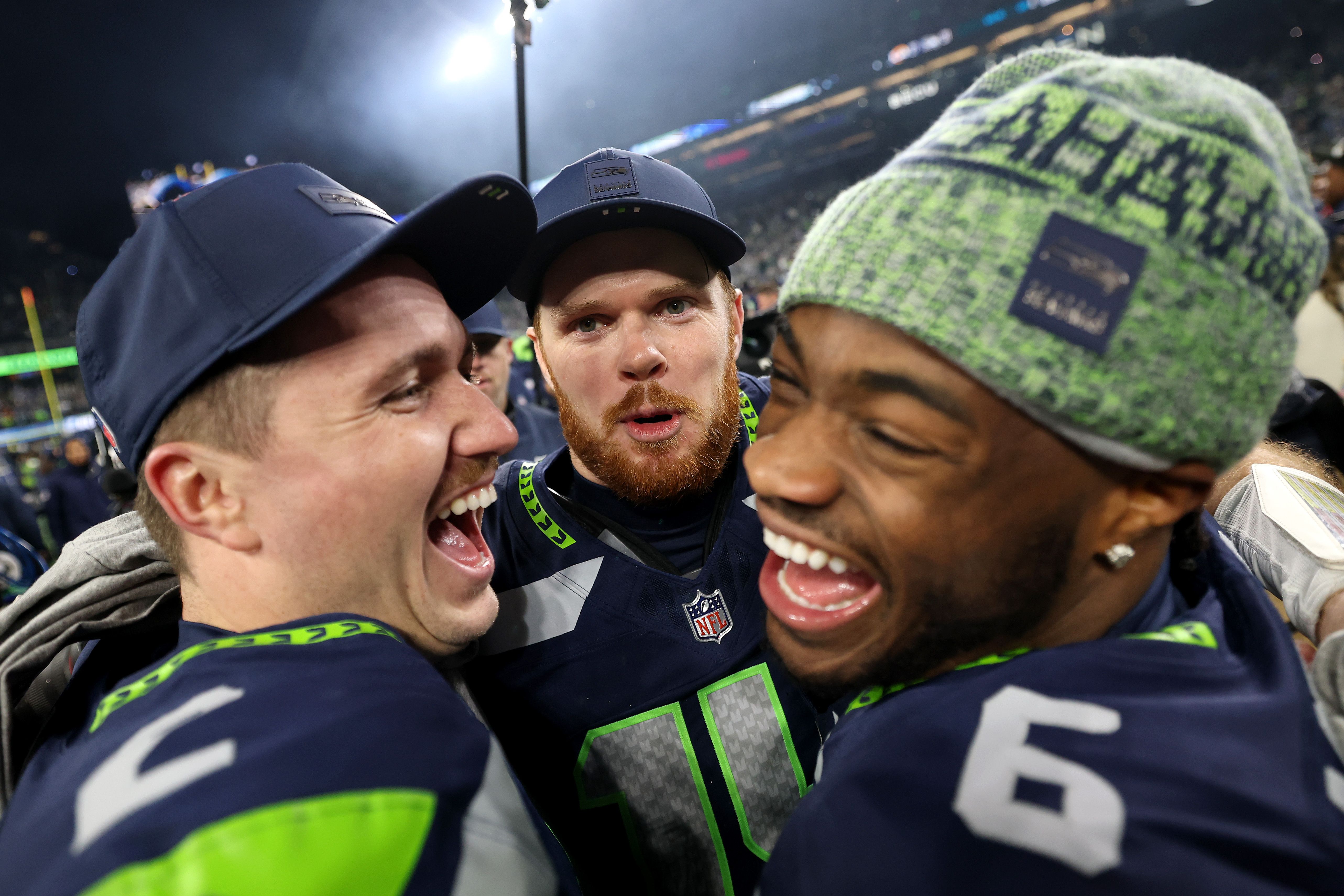 Drew Lock #2, Sam Darnold #14 and Jalen Milroe #6 of the Seattle Seahawks celebrate after defeating the Los Angeles Rams 31-27 in the NFC Championship game at Lumen Field on January 25, 2026 in Seattle, Washington. The Seahawks won 31-27.