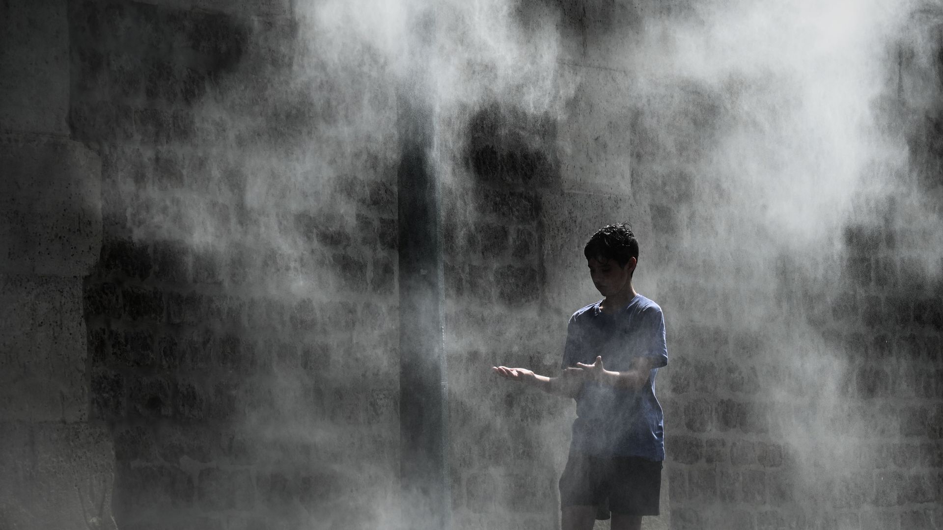 A bool cooling off under a public water spray.