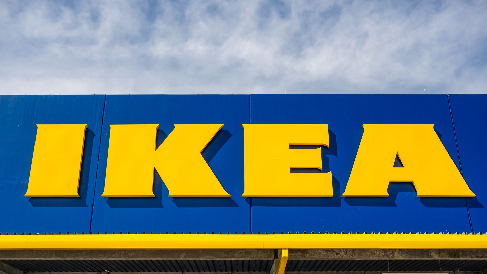A photo of an IKEA sign with the sky in the background