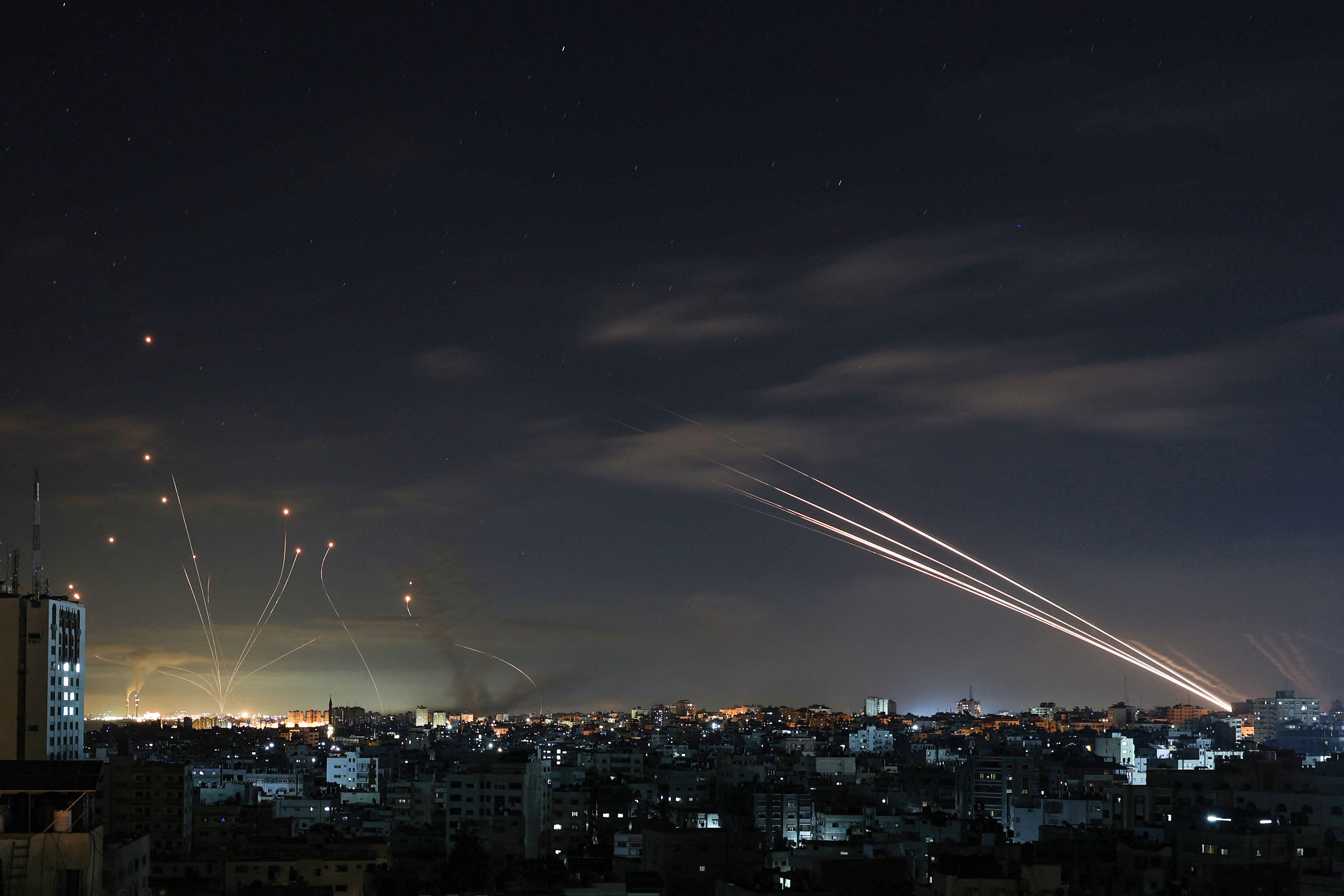  Israel's Iron Dome missile defence system (L) intercepts rockets (R) fired by the Hamas movement from Gaza city towards Israel early on May 16