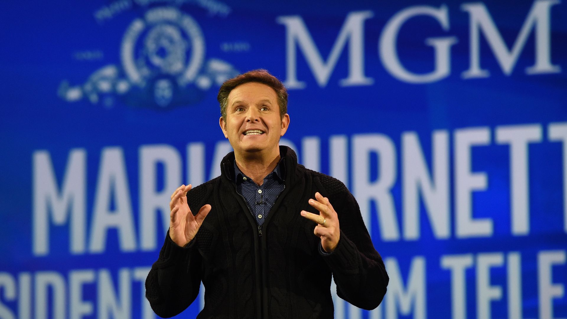 Burnett stands in front of a blue backdrop