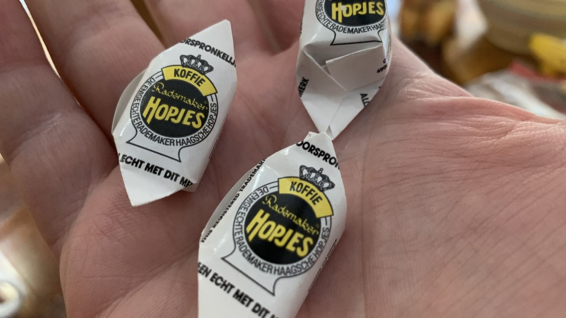 Three candy wrappers that say "Hopjes"
