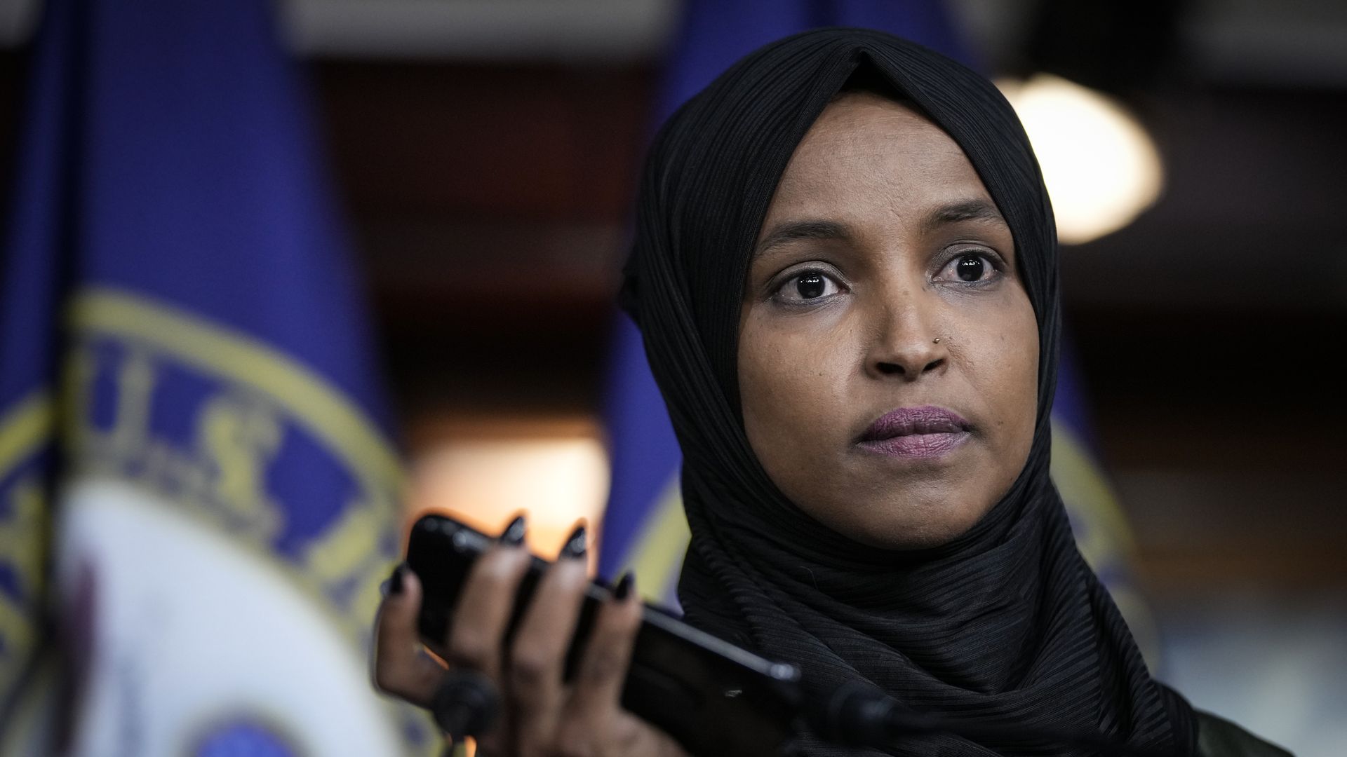 Rep. Ilhan Omar is seen holding a tape recorder as it plays a death threat made against her.