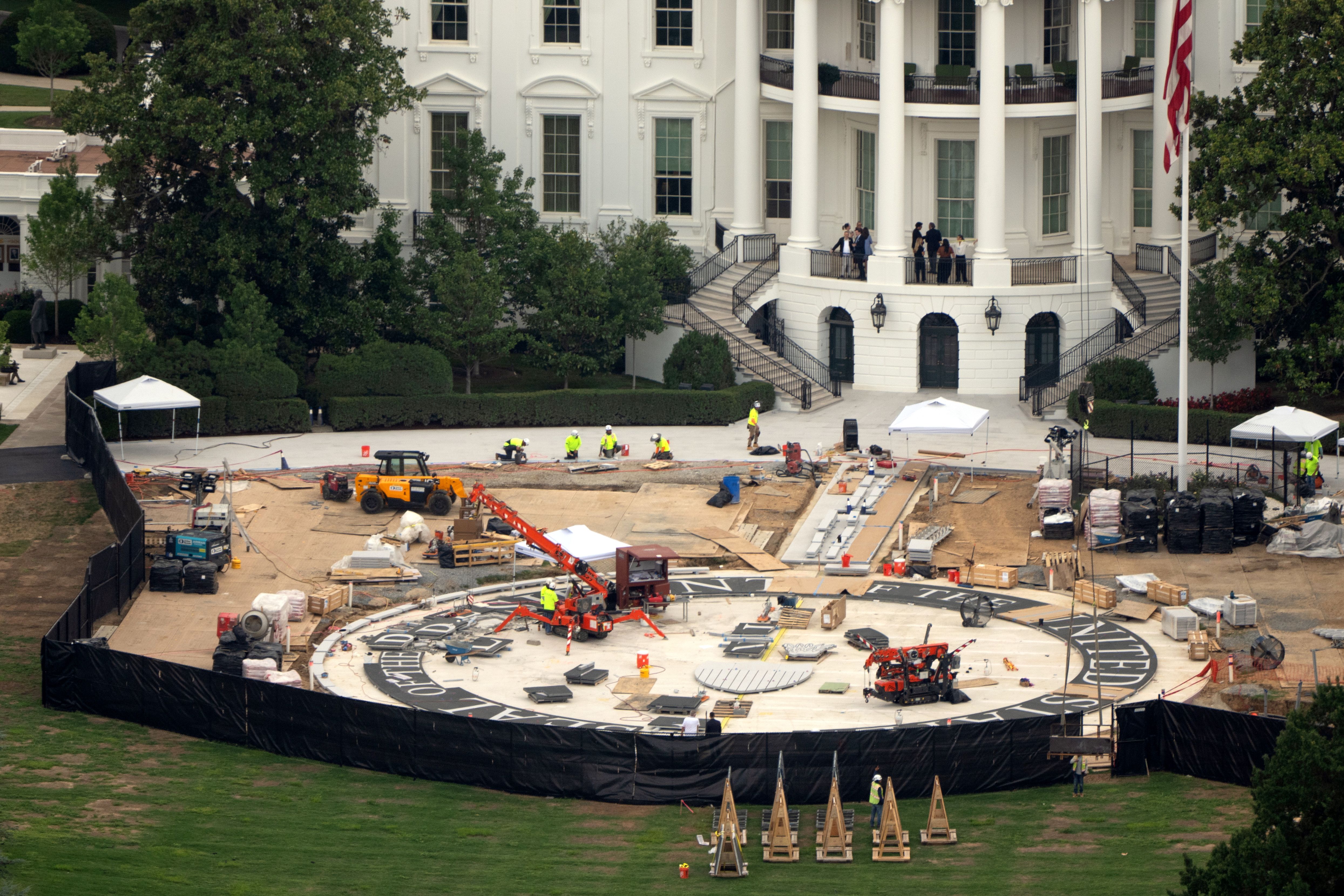 Workers build a helipad on the South Lawn of the White House.