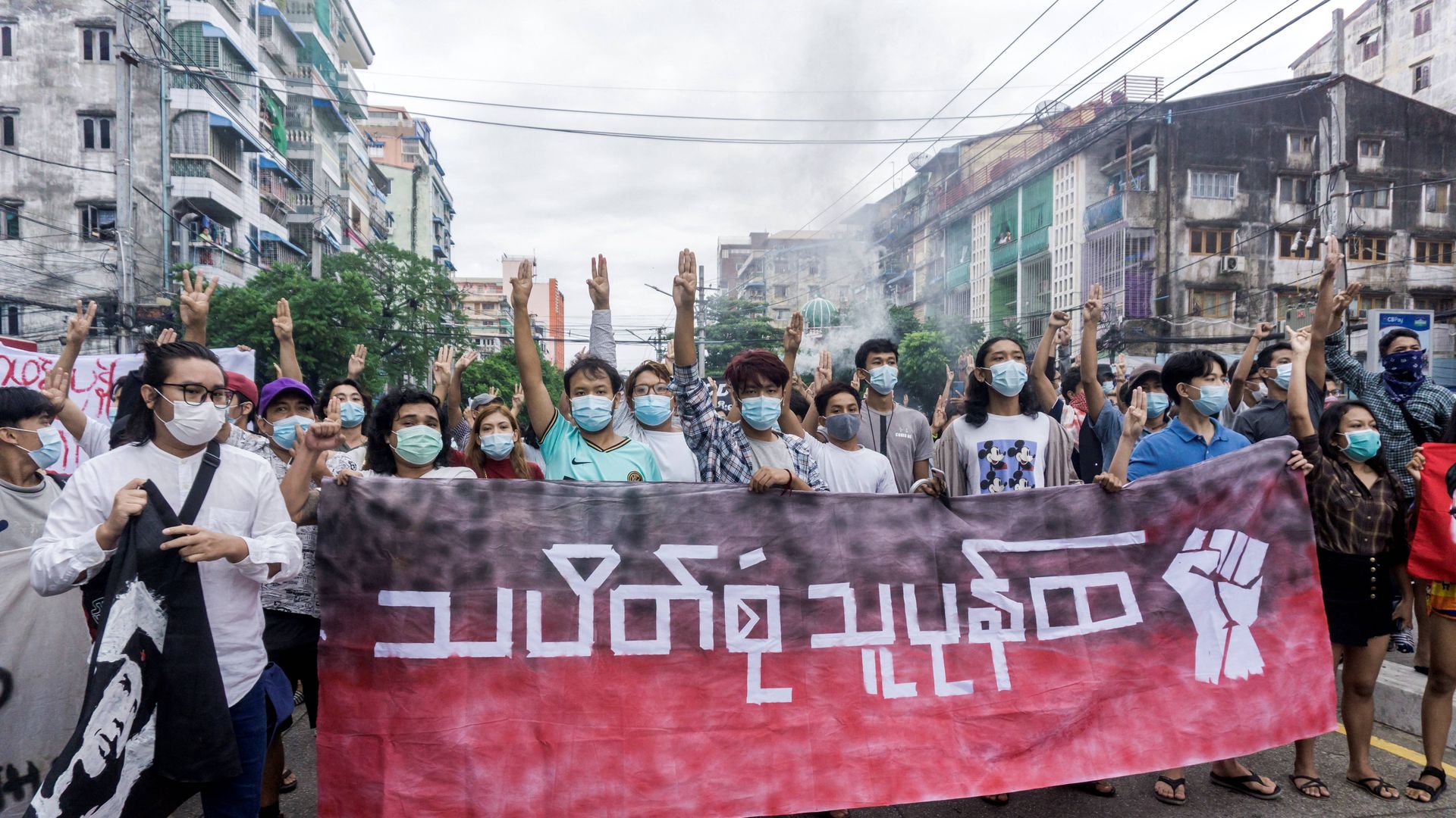 Protesters make the three-finger salute as they take part in a flash mob demonstration. 