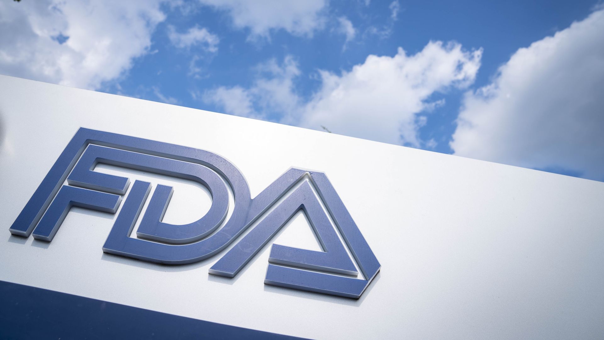 Blue FDA logo on a white sign with the sky background.