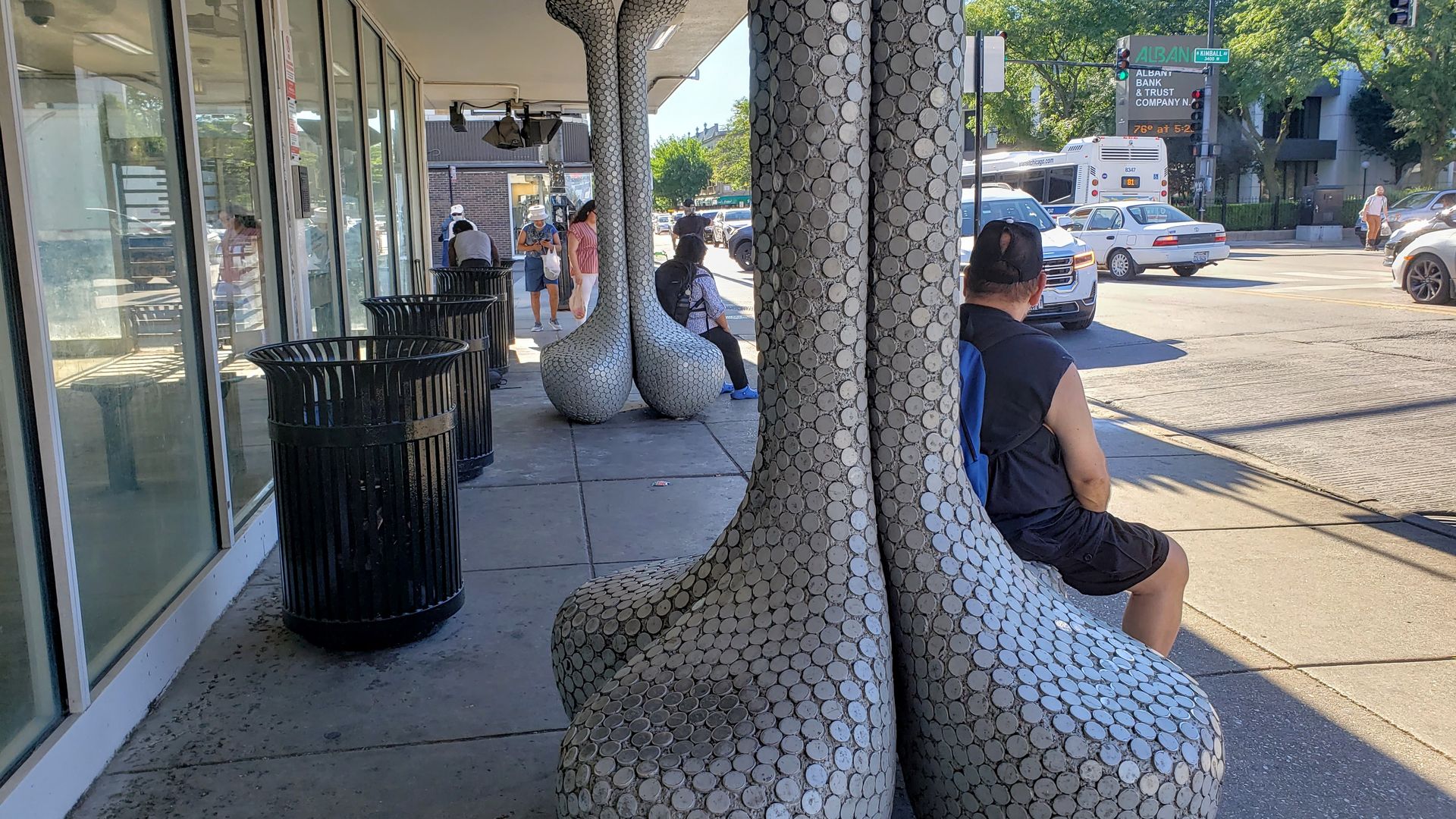 People sit on functional sculptures at the Kimball L Station