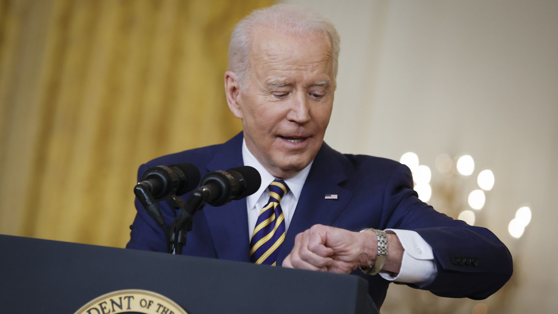 President Biden is seen checking his watch as his news conference goes into overtime on Wednesday.