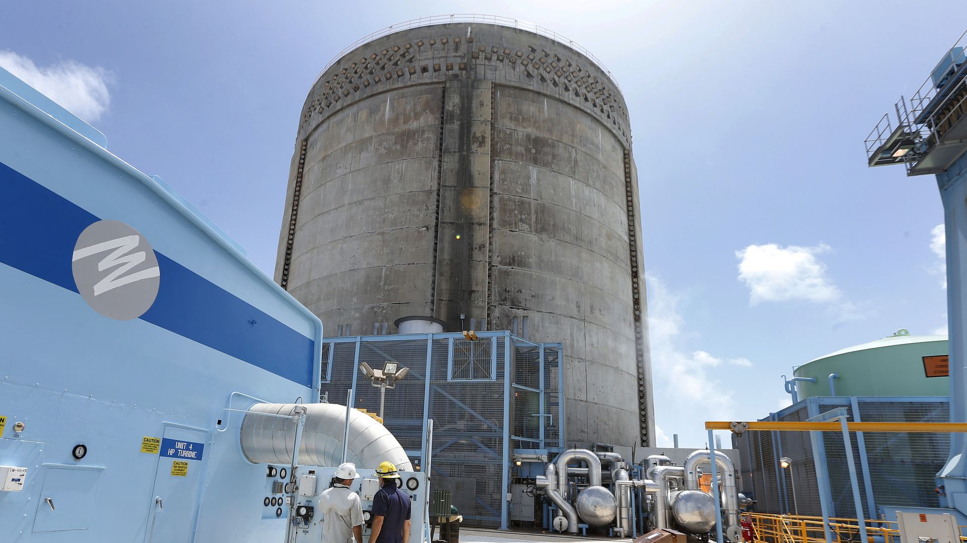 Florida Power and Light workers Juan Madruga (R) and Pehter Rodriguez (L) confer at the Turkey Point Nuclear Reactor Building in Homestead, Florida