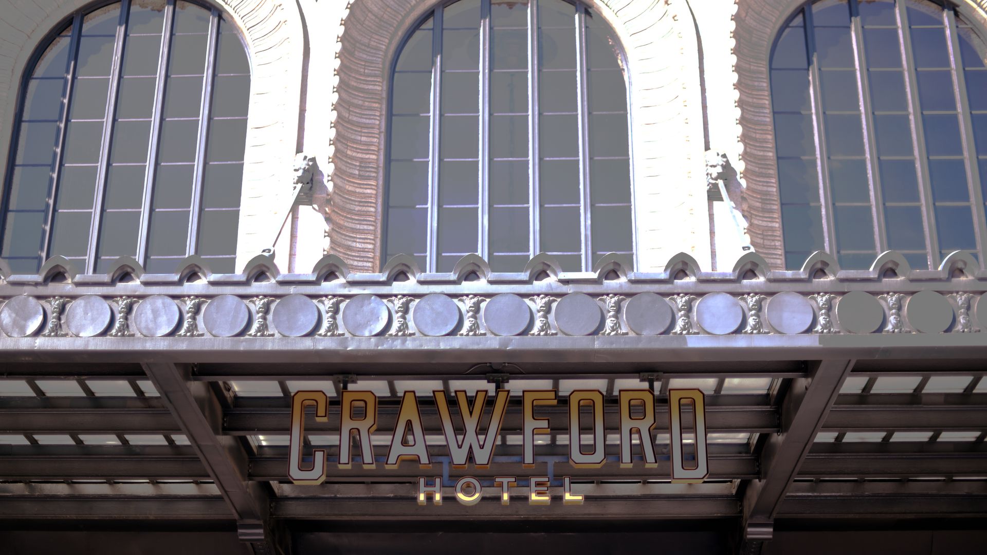 A building facade with three windows and the words CRAWFORD HOTEL on the sign.