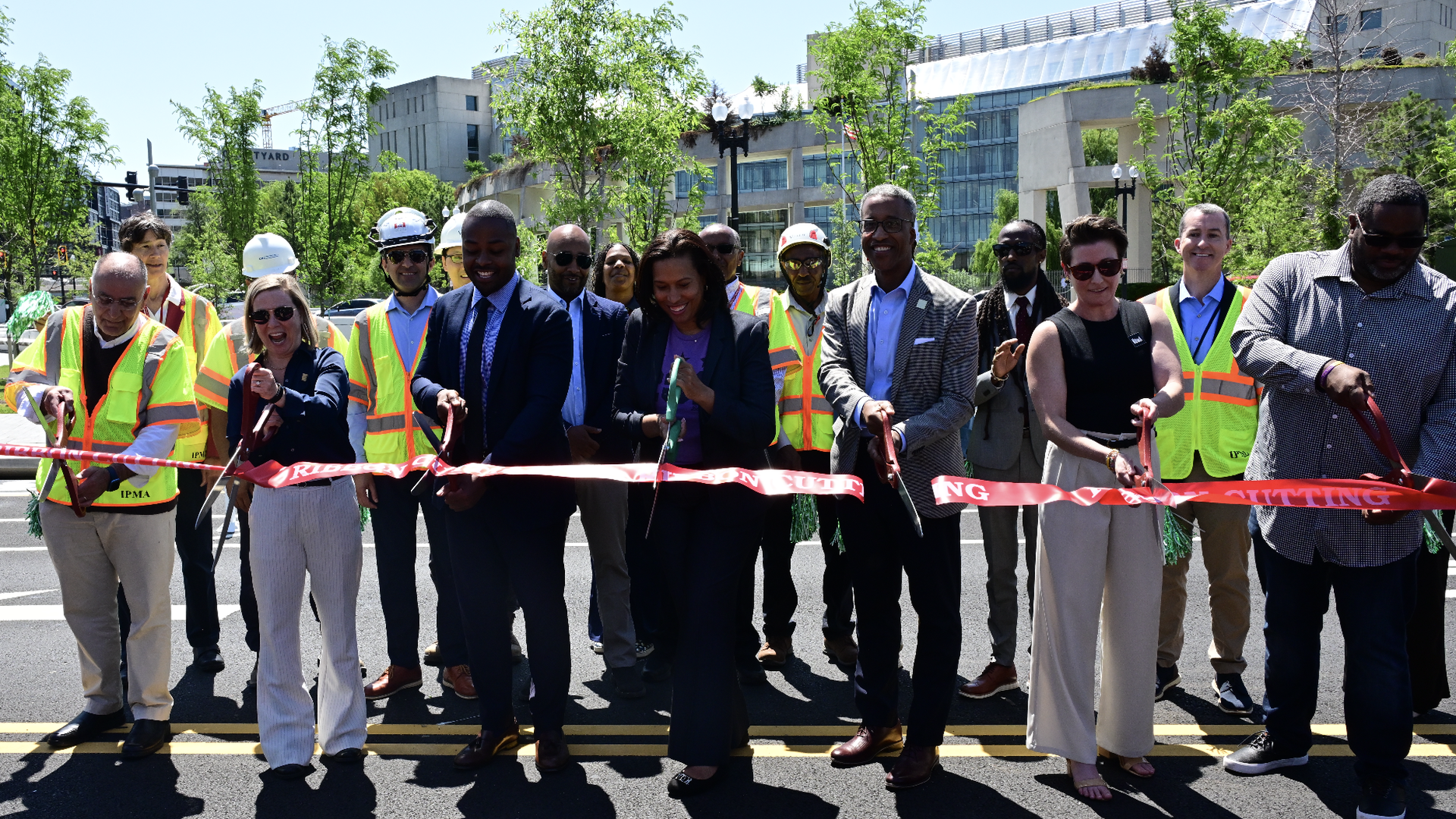 Mayor Muriel Bowser and city officials rub ribbon on new plaza
