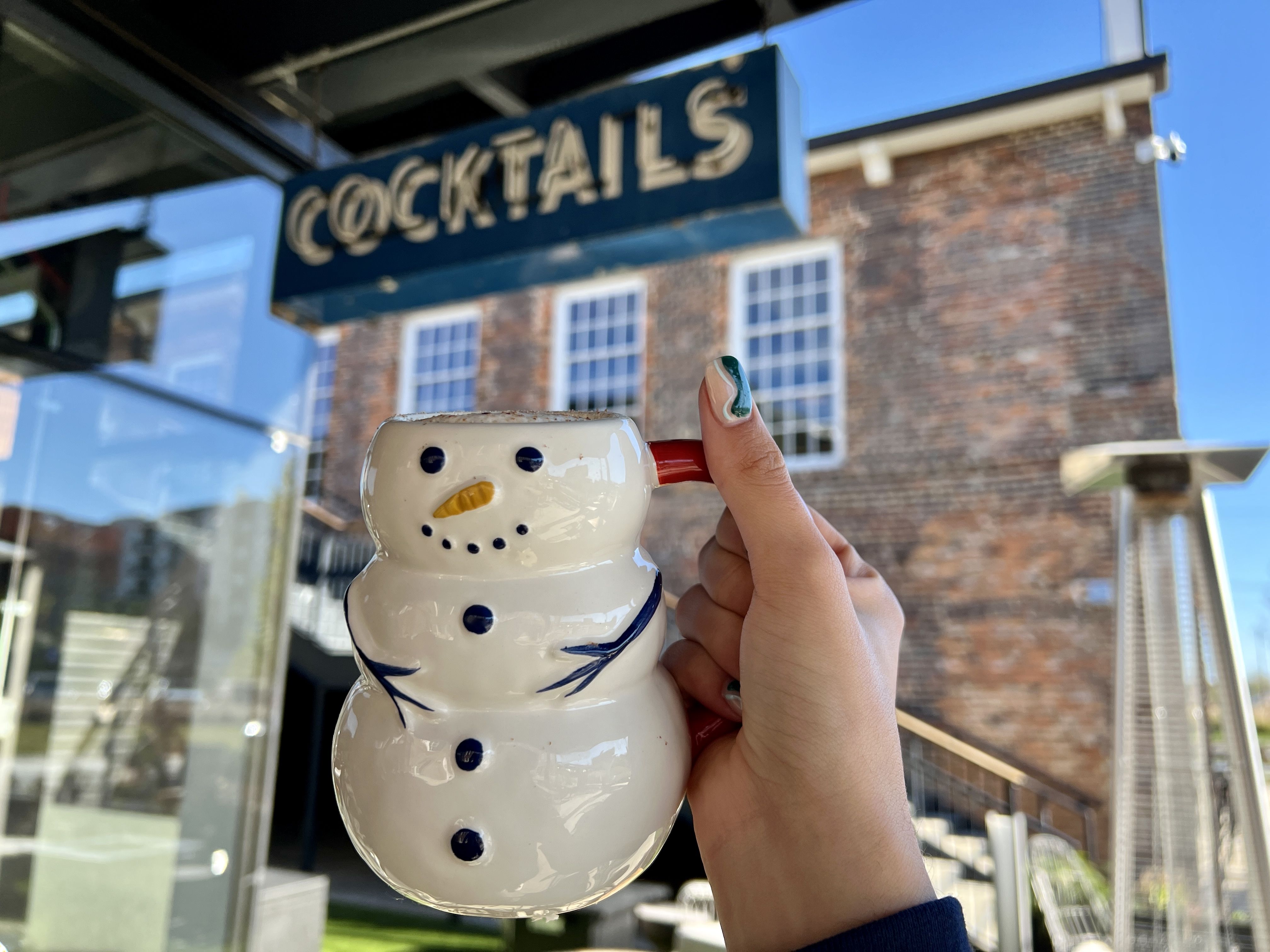 hand holding mug in shape of snowman