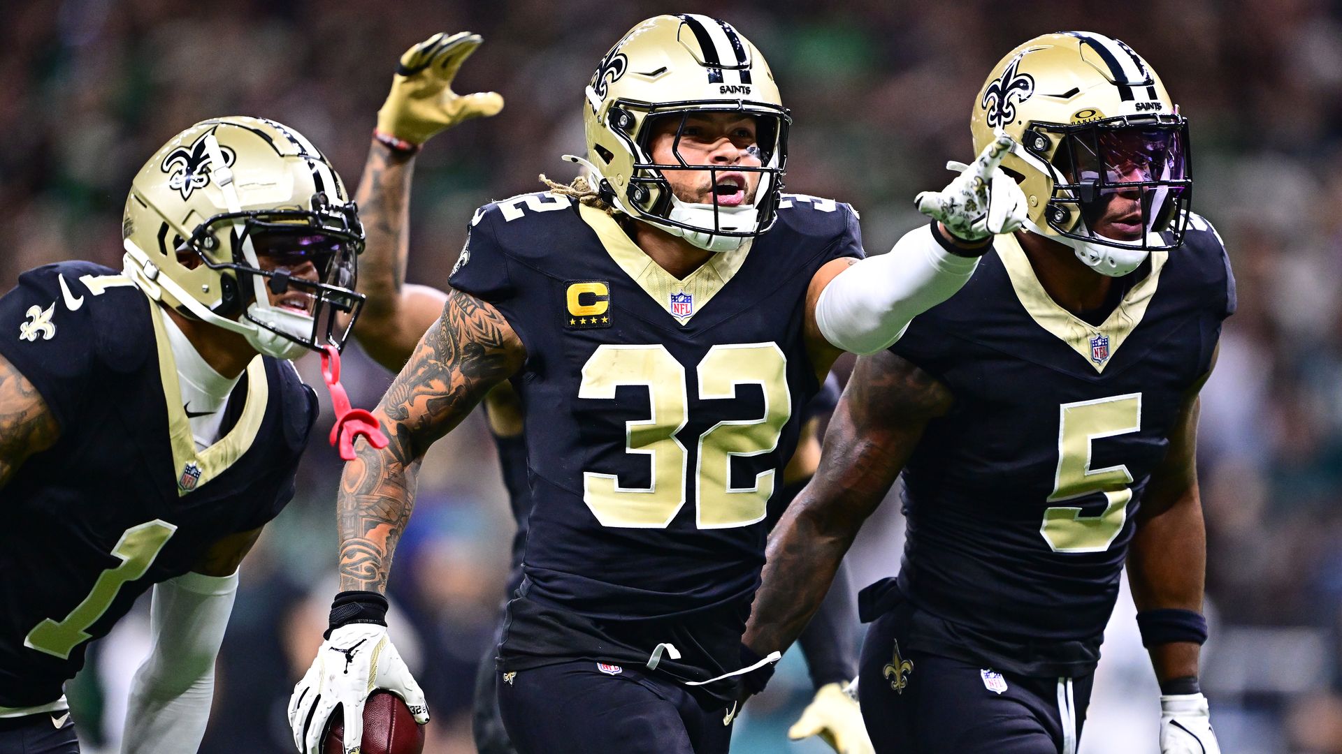 Tyrann Mathieu and other Saints players walk together and gesture ahead of themselves.