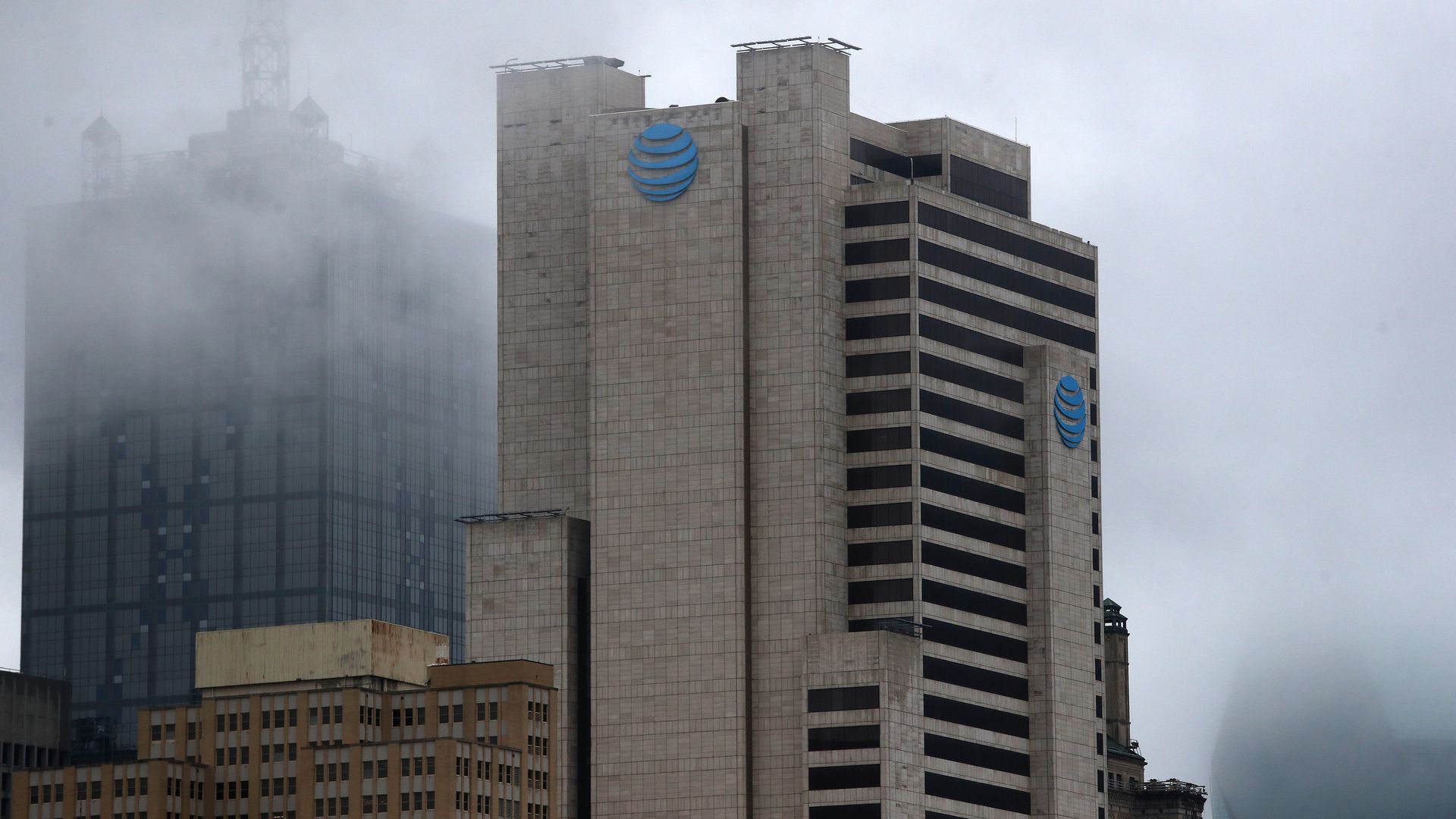 The AT&T building in downtown Dallas, outlined in a creeping fog.
