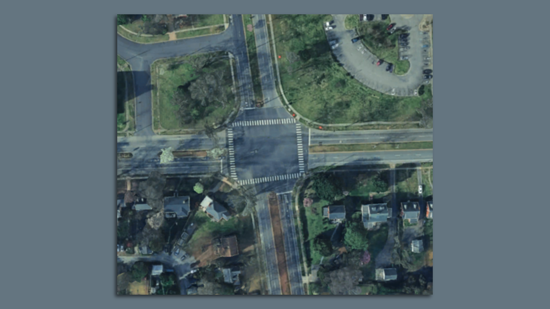 A screenshot of a Google Earth picture of an intersection with a square in the middle.