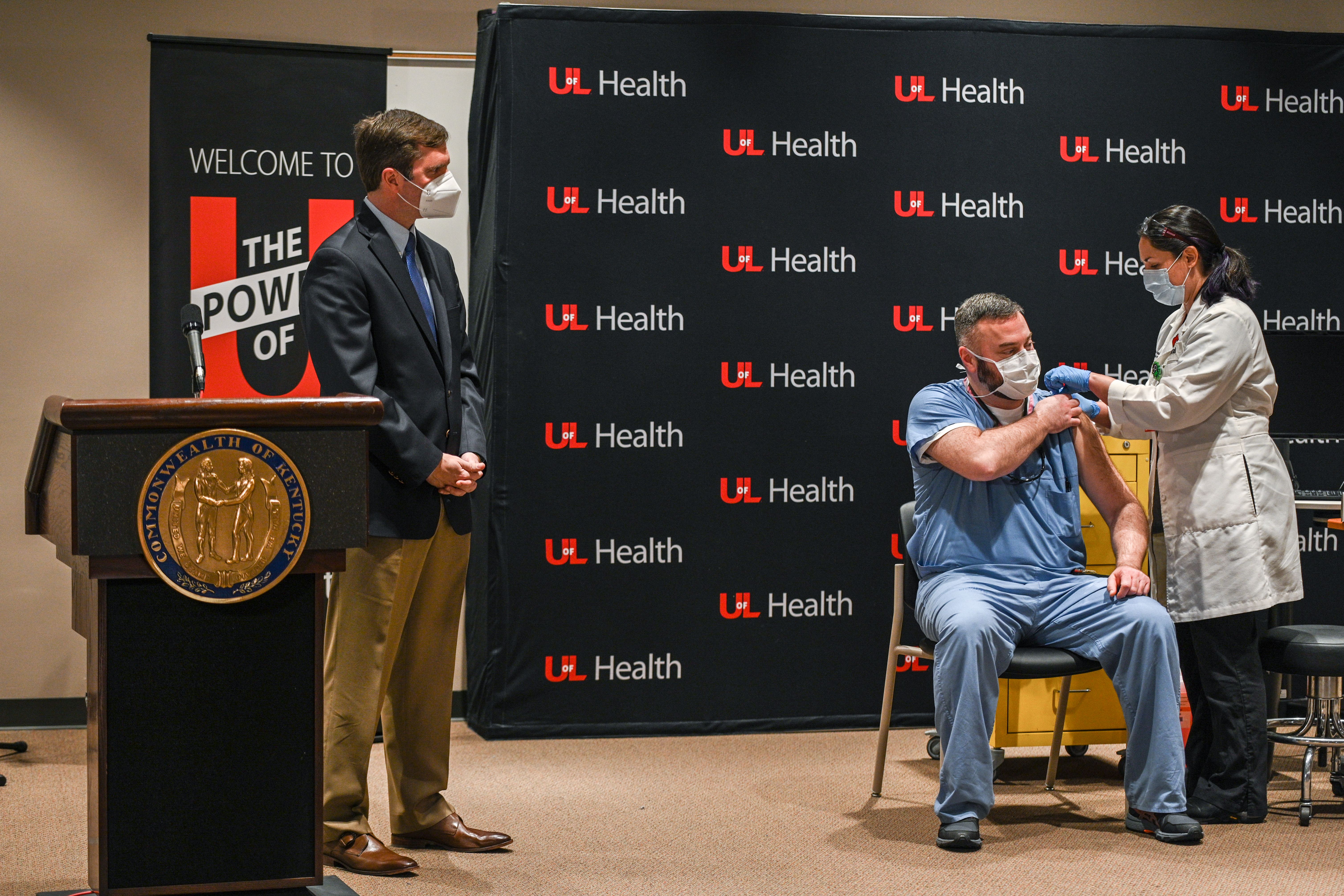 Gov. Andy Beshear watches as Dr. Jason Smith receives a COVID-19 vaccination on Monday in Louisville, Kentucky. Photo: Jon Cherry/Getty Images