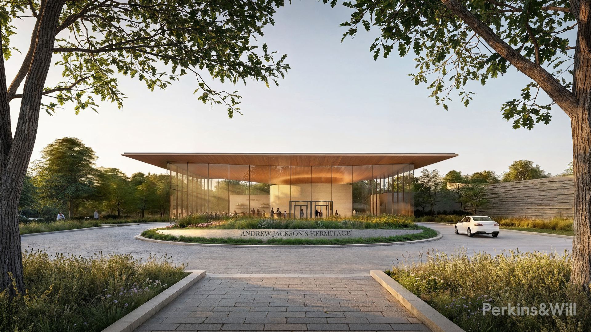 Contemporary glass pavilion with a flat wooden roof sits in a circular driveway at the curb reading "ANDREW JACKSON'S HERMITAGE," framed by large trees; a few people and a white car nearby.