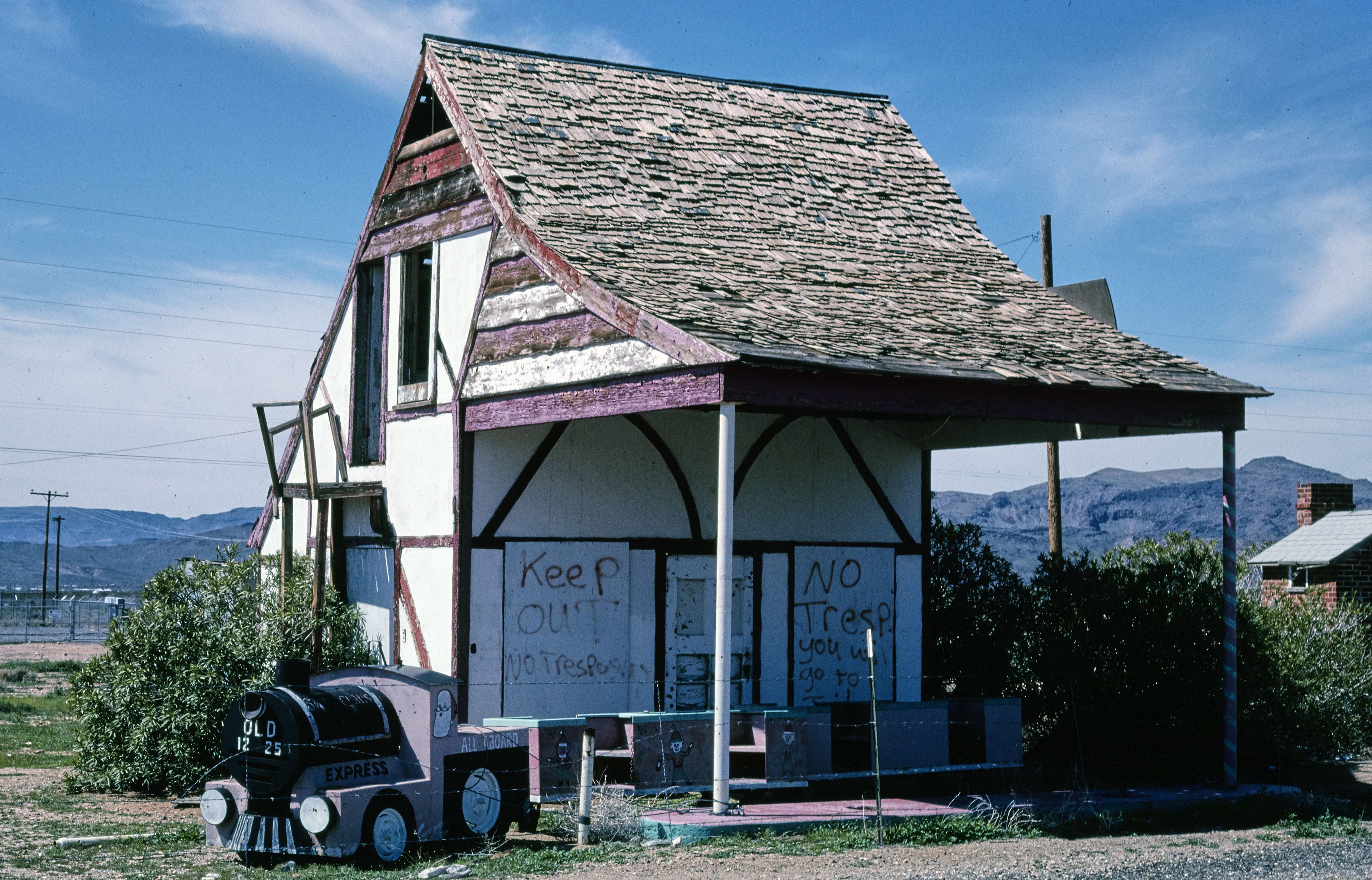 An abandoned building that says "keep out" and a derailed children's train.