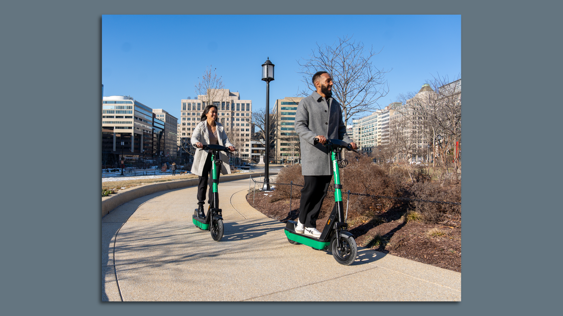 Image of two people riding scooters on a sidewalk in Washington, D.C.