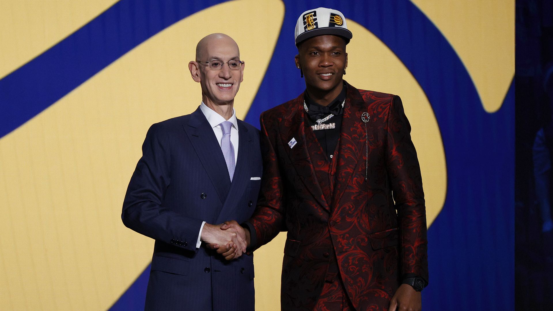 NBA commissioner shaking hands with a player during the draft.