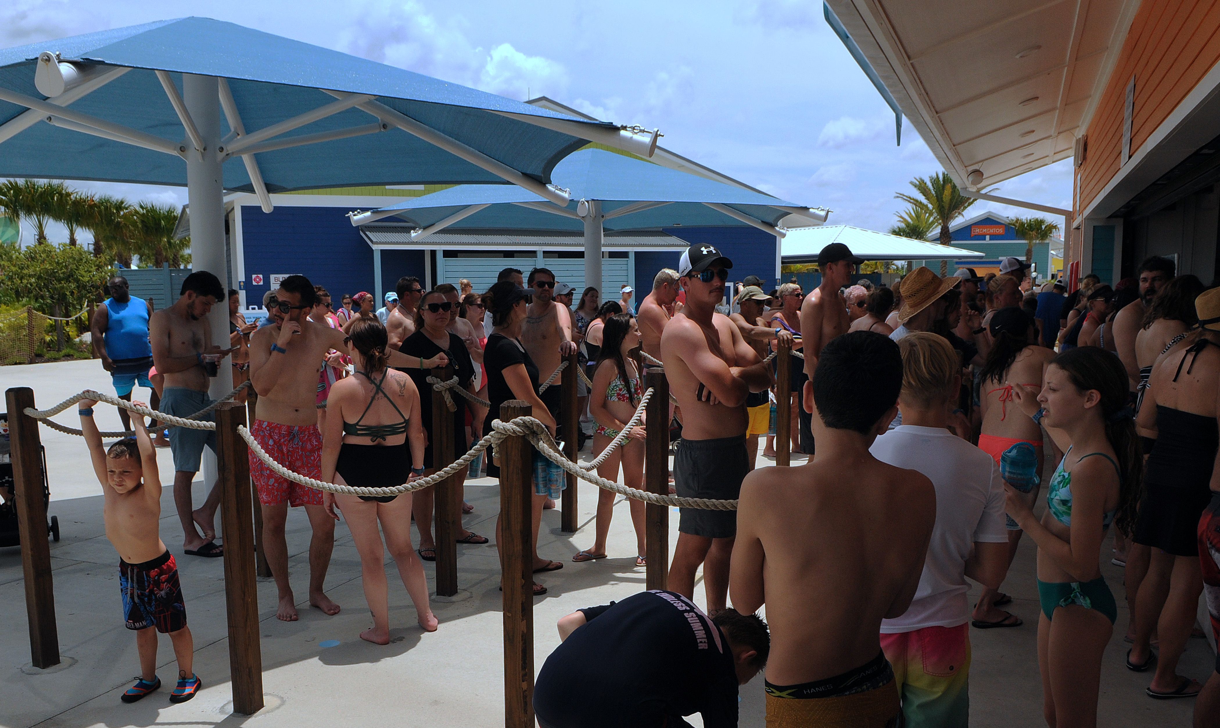 People wait in a queue at a snack bar at Island H2O Live! water park as the attraction becomes the only major water park in the Orlando area to reopen for Memorial Day weekend 