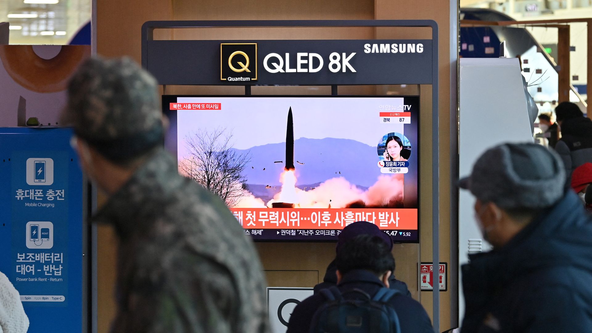 People watch a television screen showing a news broadcast with file footage of a North Korean missile test, at a railway station in Seoul on January 17.