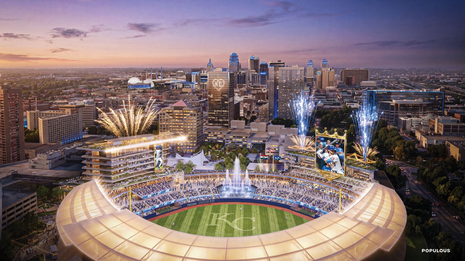 Aerial view of a large baseball stadium at sunset with fireworks, a cheering crowd, a big video screen showing a player, and a city skyline behind; KC initials on the field.