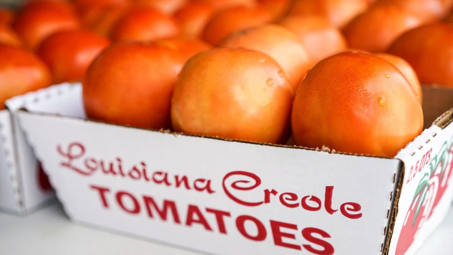 Photo shows red tomatoes in a box that says "Louisiana Creole tomatoes."