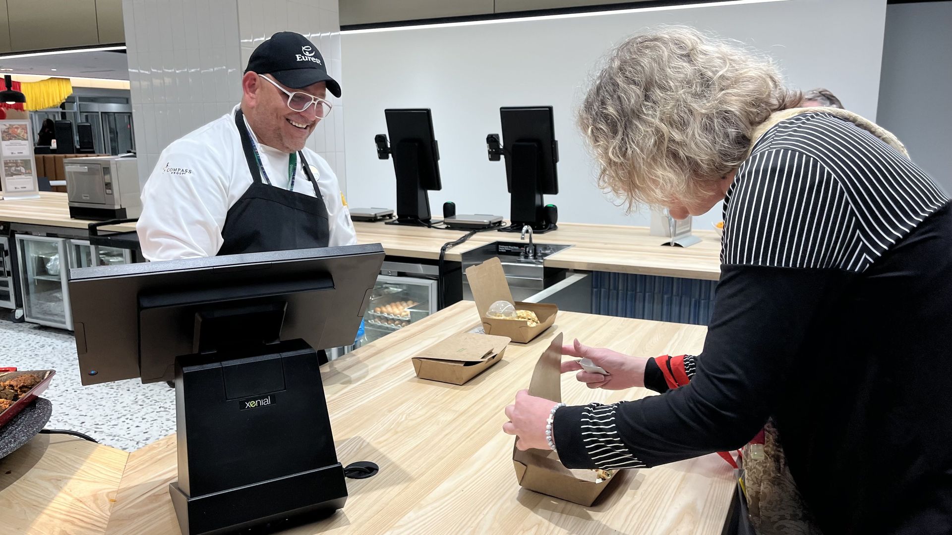 Person picks up food from a food hall stall
