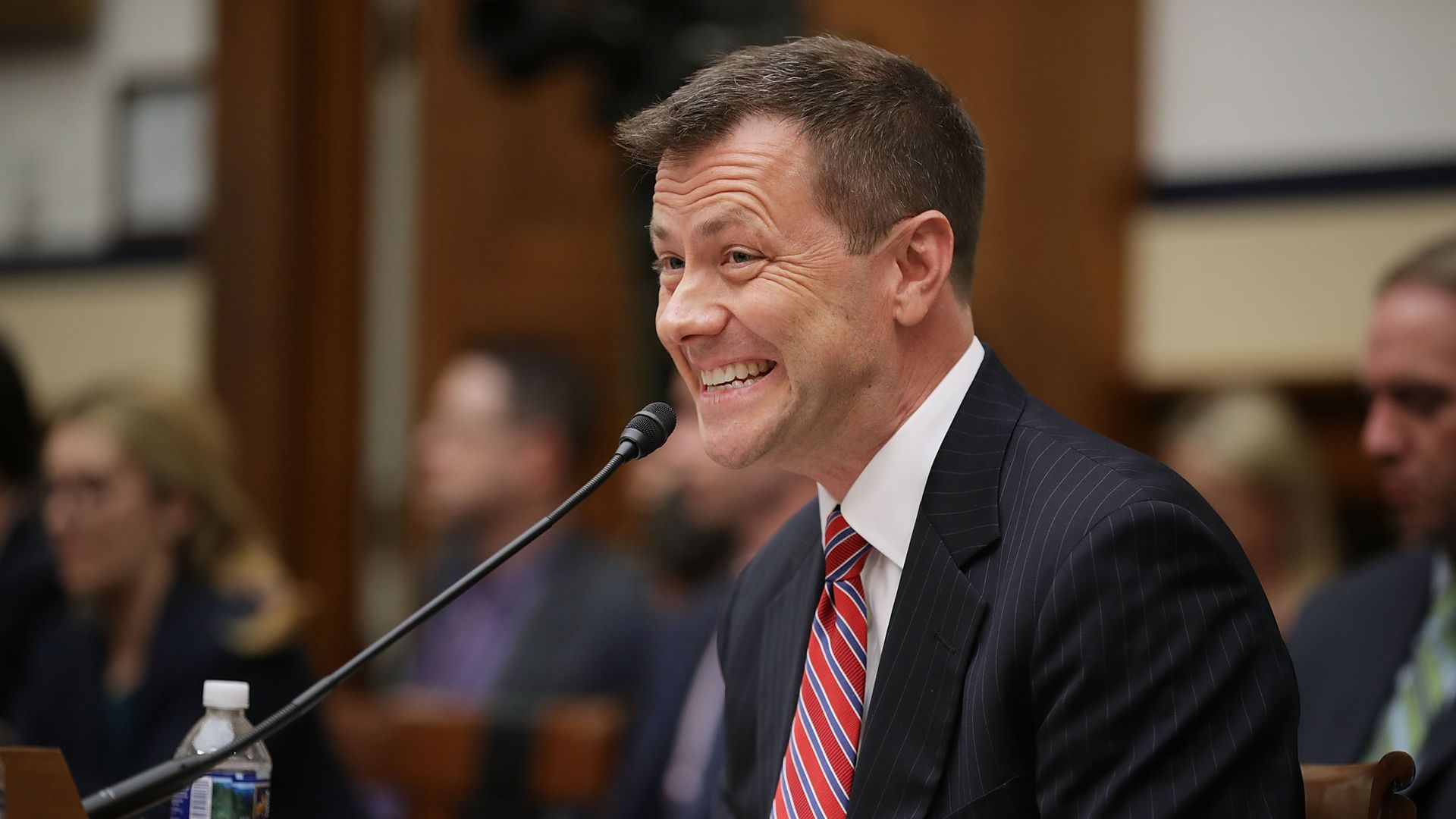 Peter Strzok testifying to Congress grimaces into a microphone