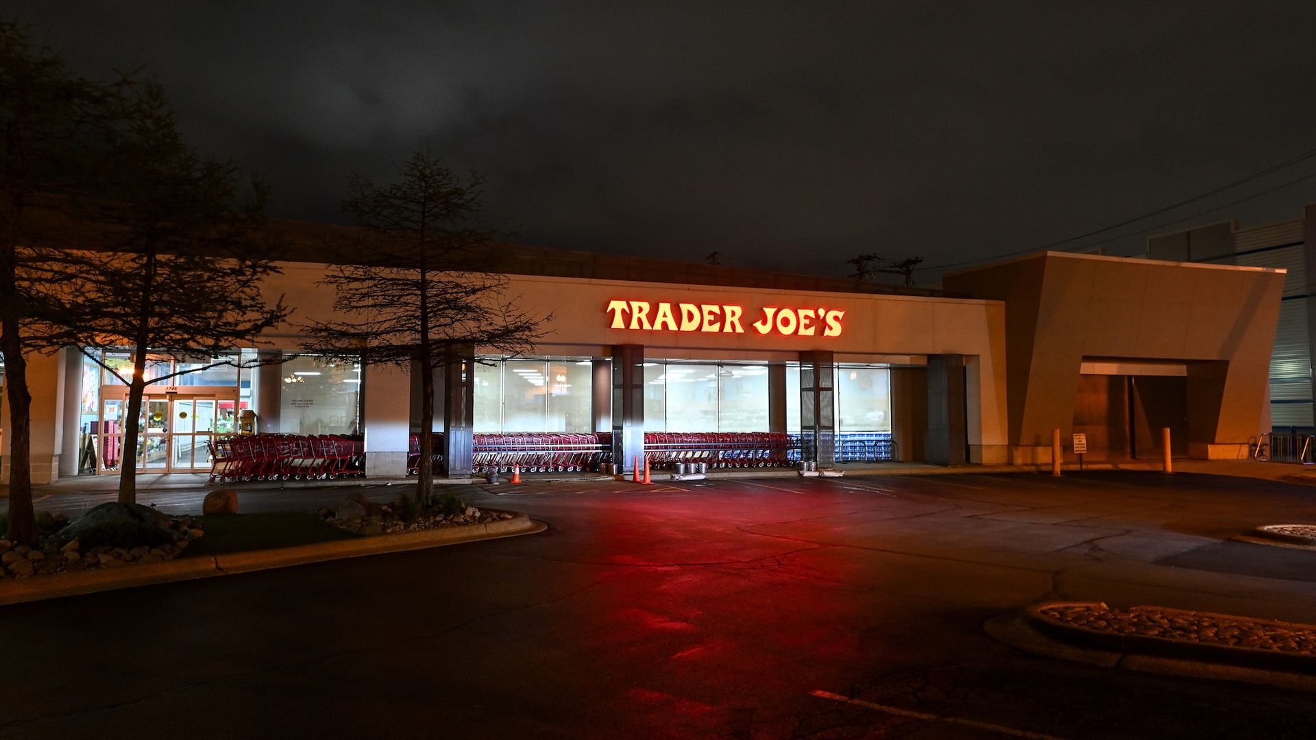 A Trader Joe's grocery store at night with an empty parking lot.