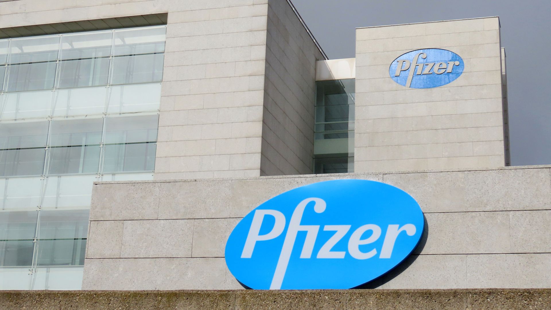 Two blue Pfizer logos on a white headquarters building.