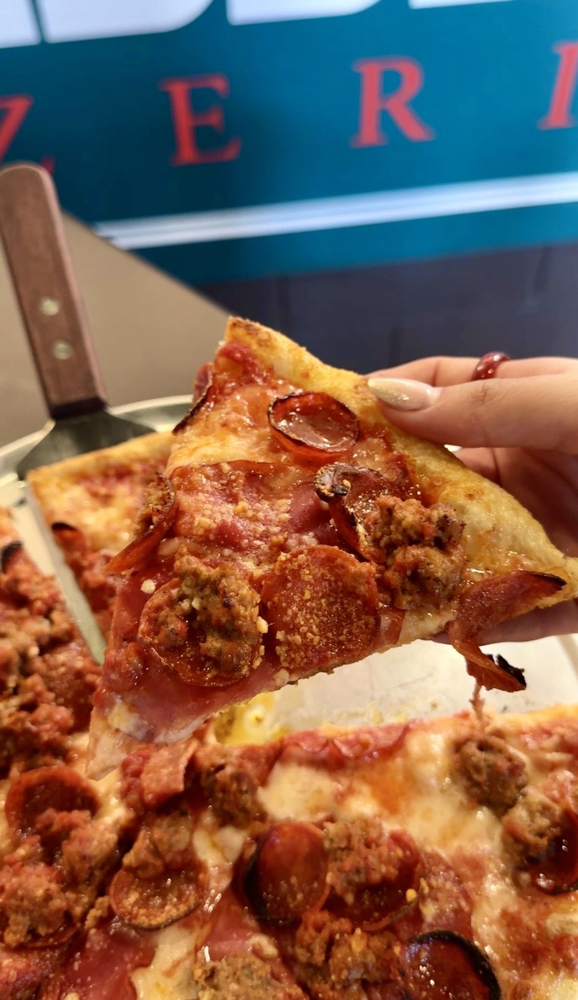 hand holding pizza slice