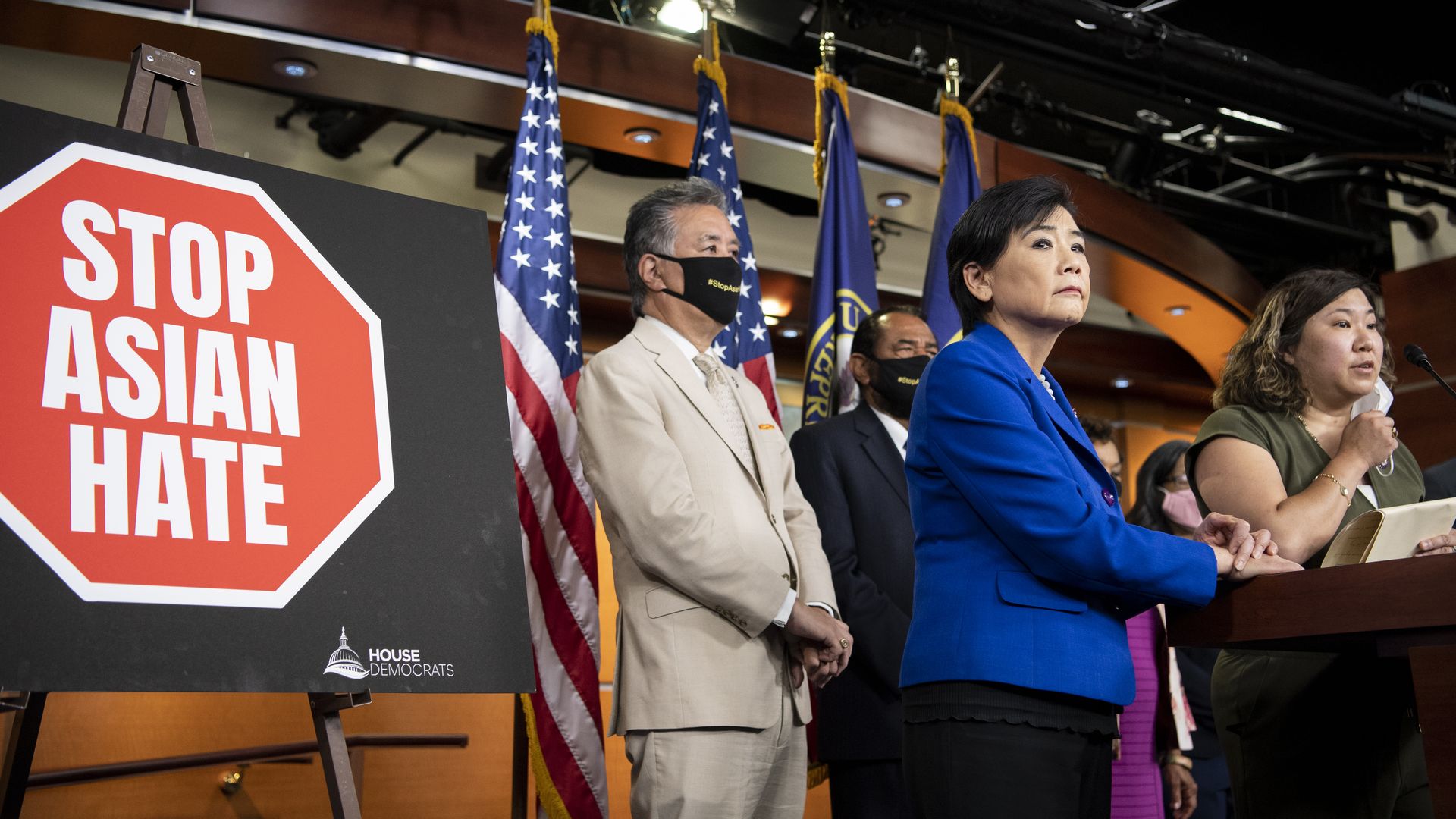 Photo of Asian American lawmakers standing at the podium with a sign that says "Stop Asian Hate" to their right