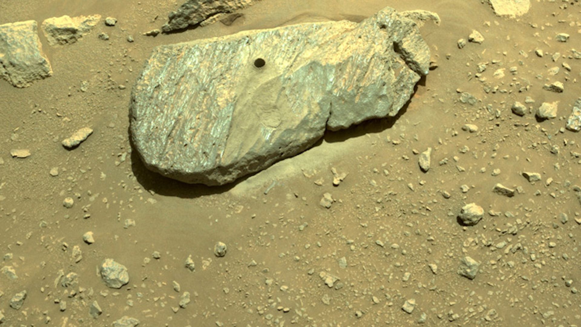A drilled hole through a rock on Mars