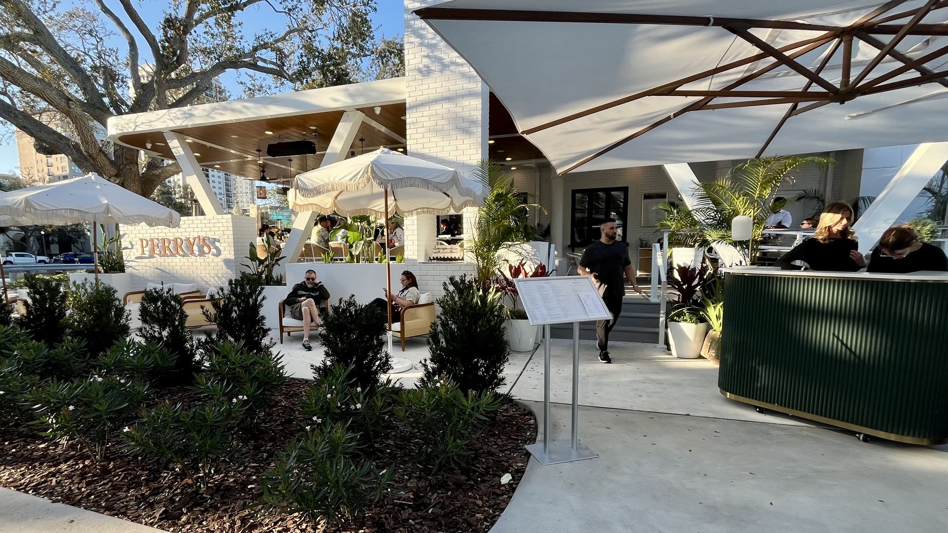 A restaurant patio a white-brick wall that reads "PERRY'S" in tan letters.