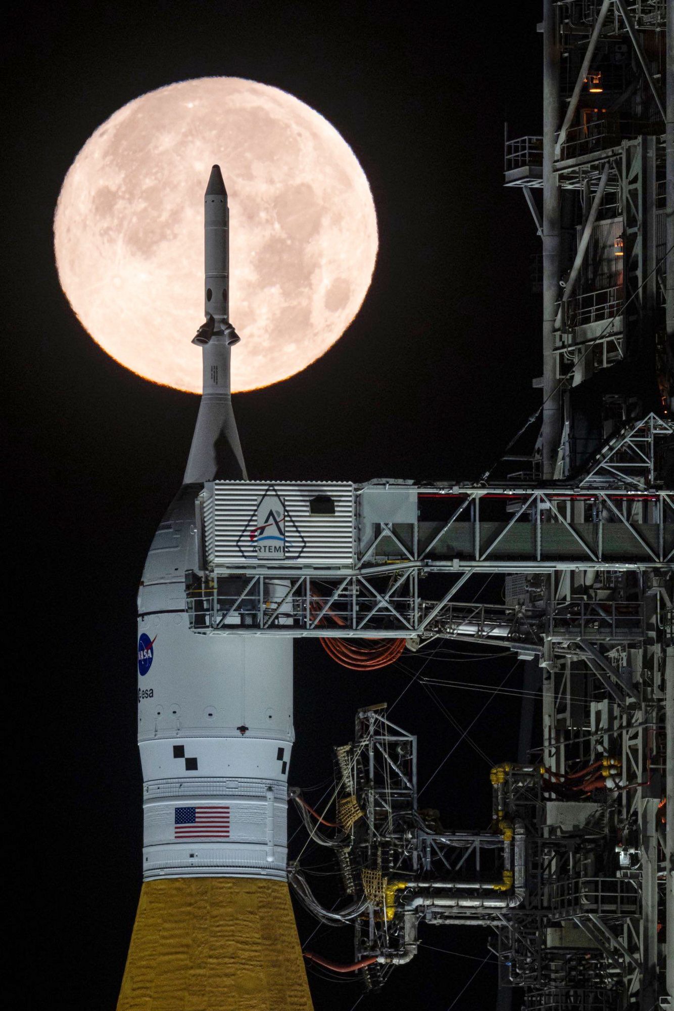 A full moon is seen shining over NASA’s SLS (Space Launch System) and Orion spacecraft, atop the mobile launcher in the early hours of Sunday, Feb. 1, 2026, at NASA’s Kennedy Space Center in Florida. (Sam Lott/NASA via AP)
