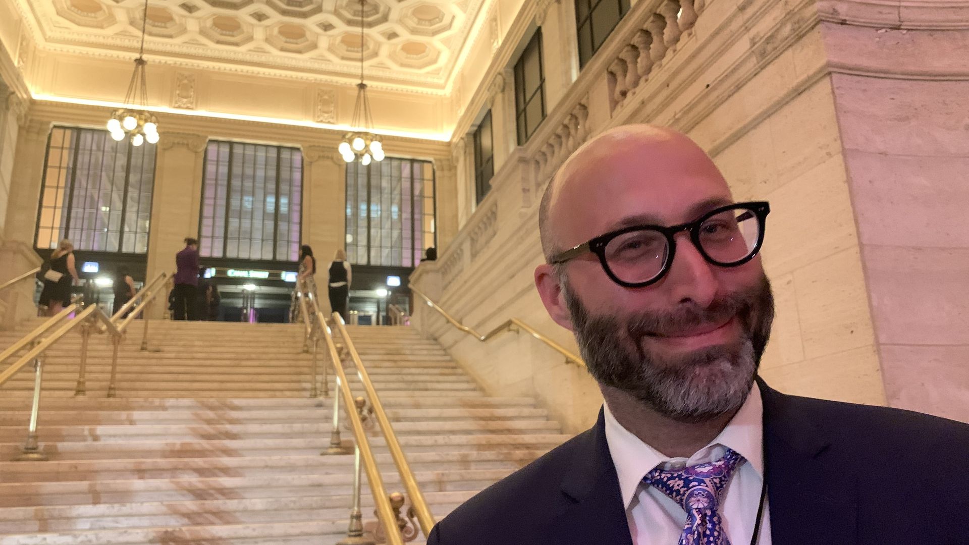 Photo of a man standing in front of stairs. 