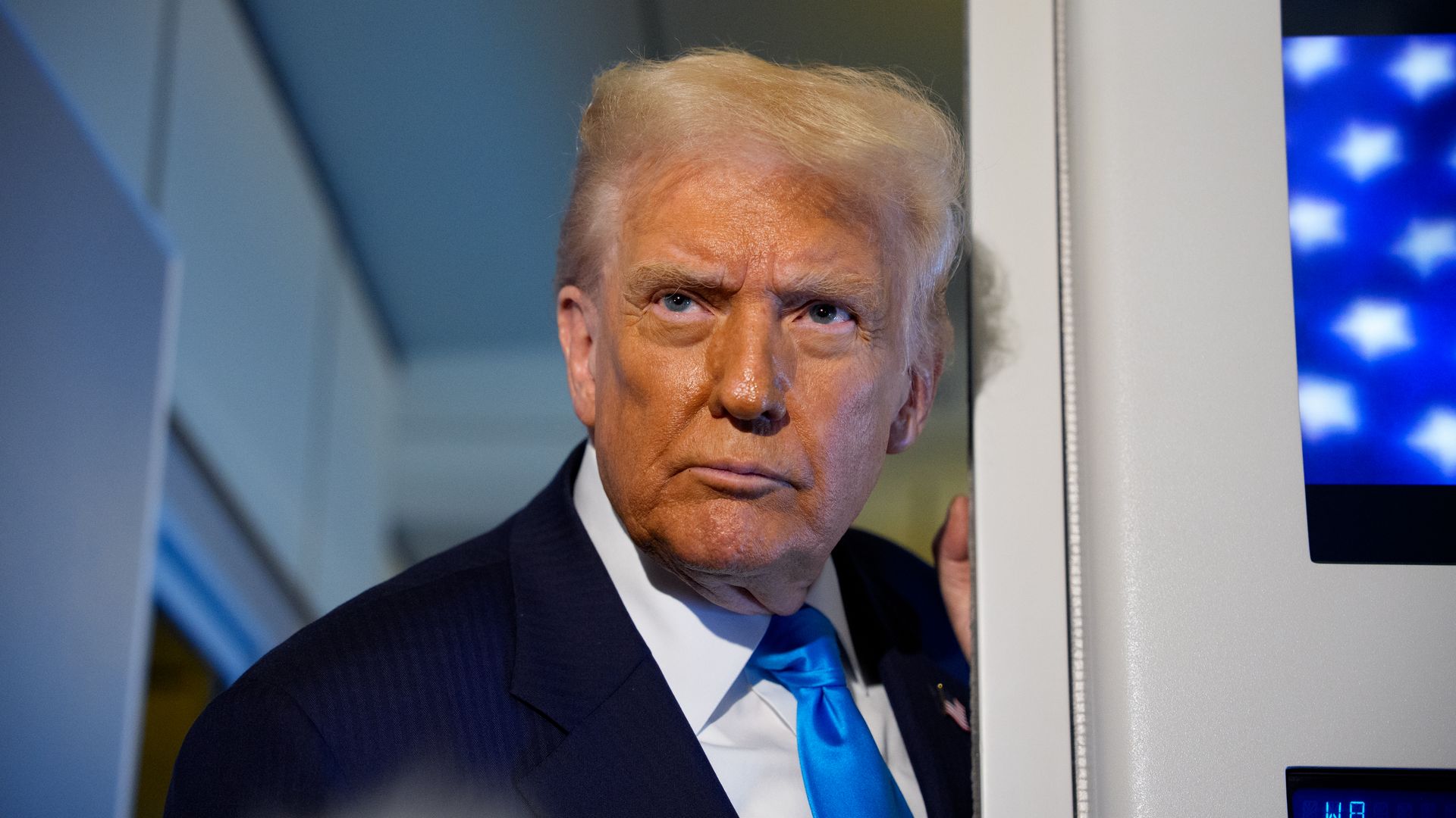 Trump stands in a doorway
