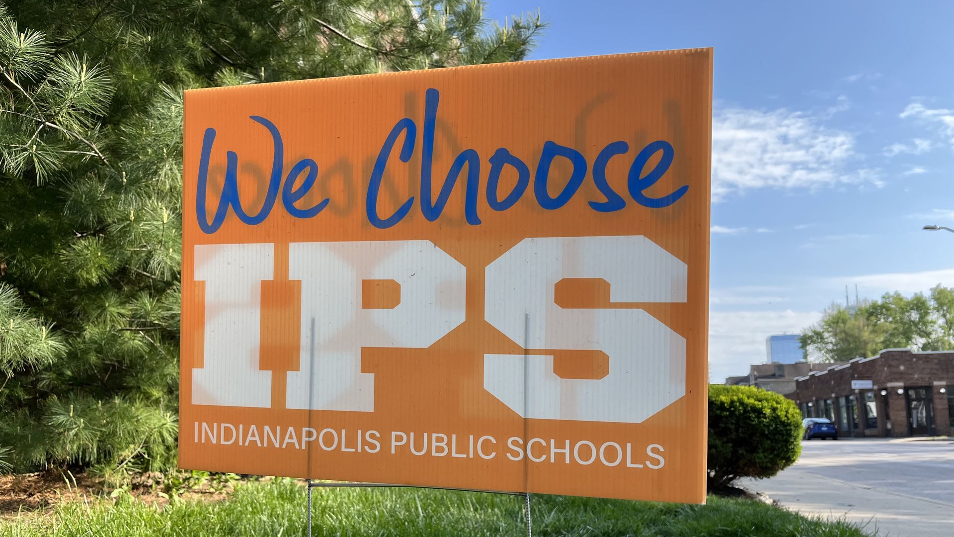 An orange sign that says we choose IPS