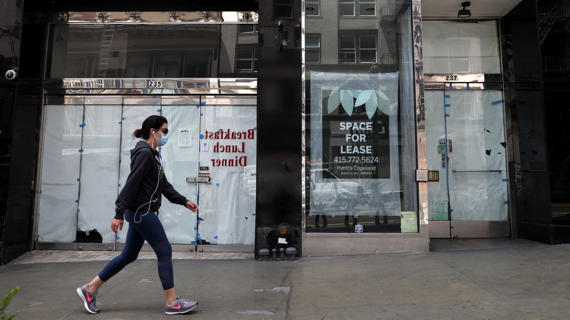 A person walks past a closed store in San Francisco.