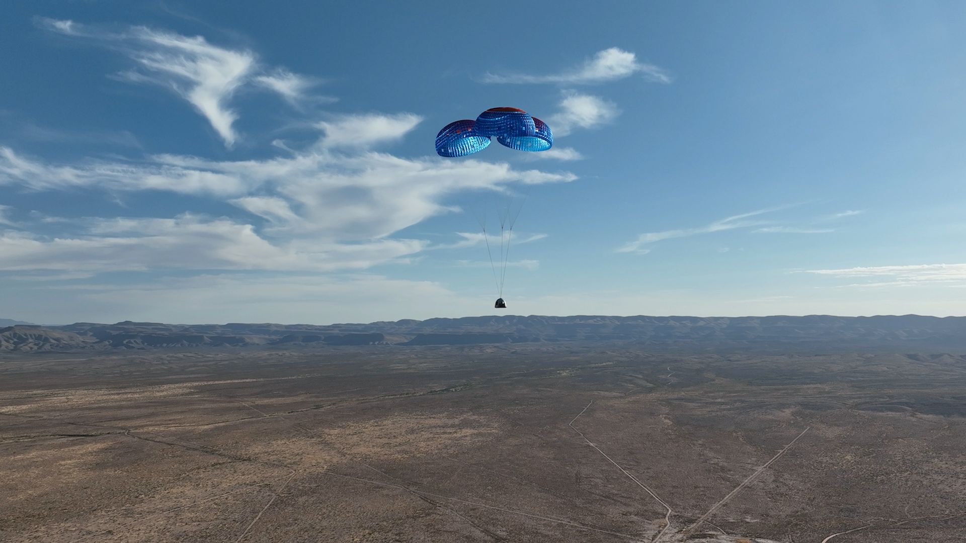 A Blue Origin crew capsule descends in Texas under parachutes