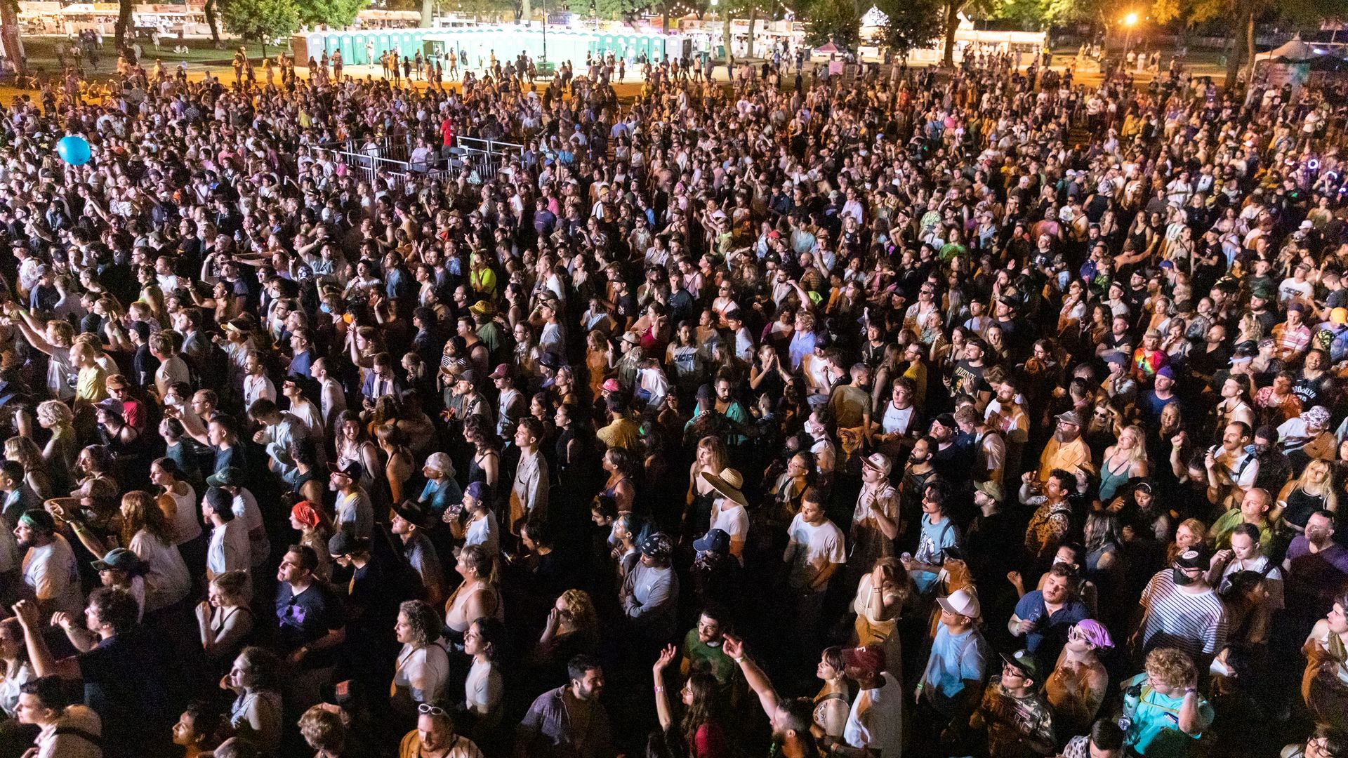 Photo of thousands of people watching a concert outside 