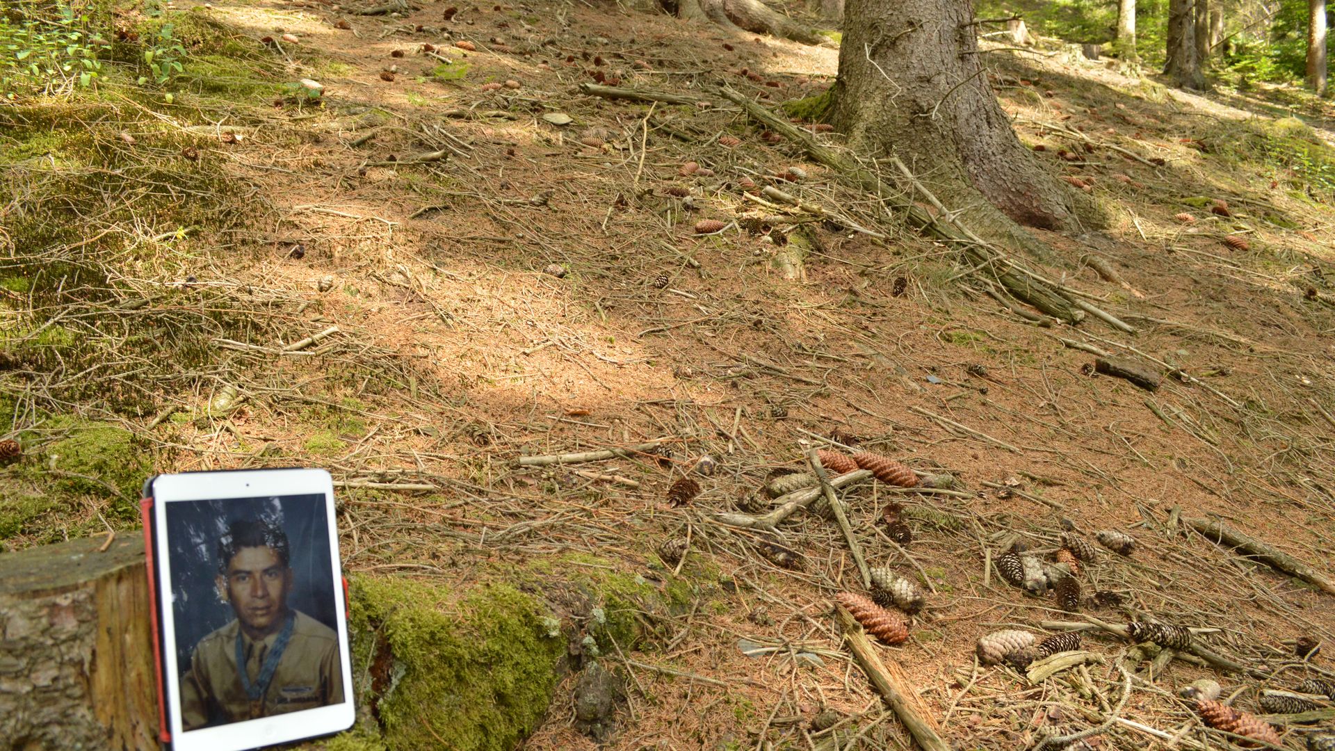 A photo of World War II Medal of Honor recipient Macario Garcia on a iPad sits in Germany's Hürtgen Forest where he performed his heroric deeds.