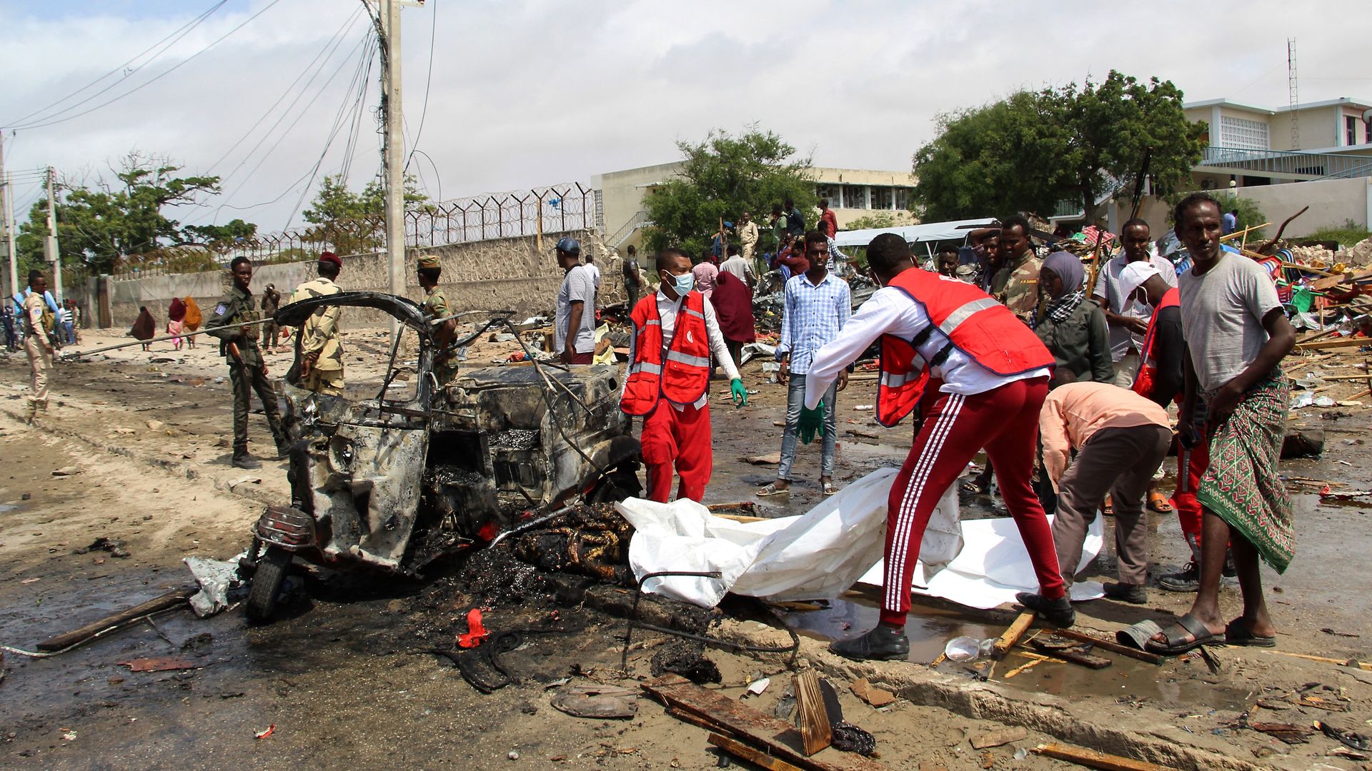 Picture of medical workers in Somalia standing next to an exploded car