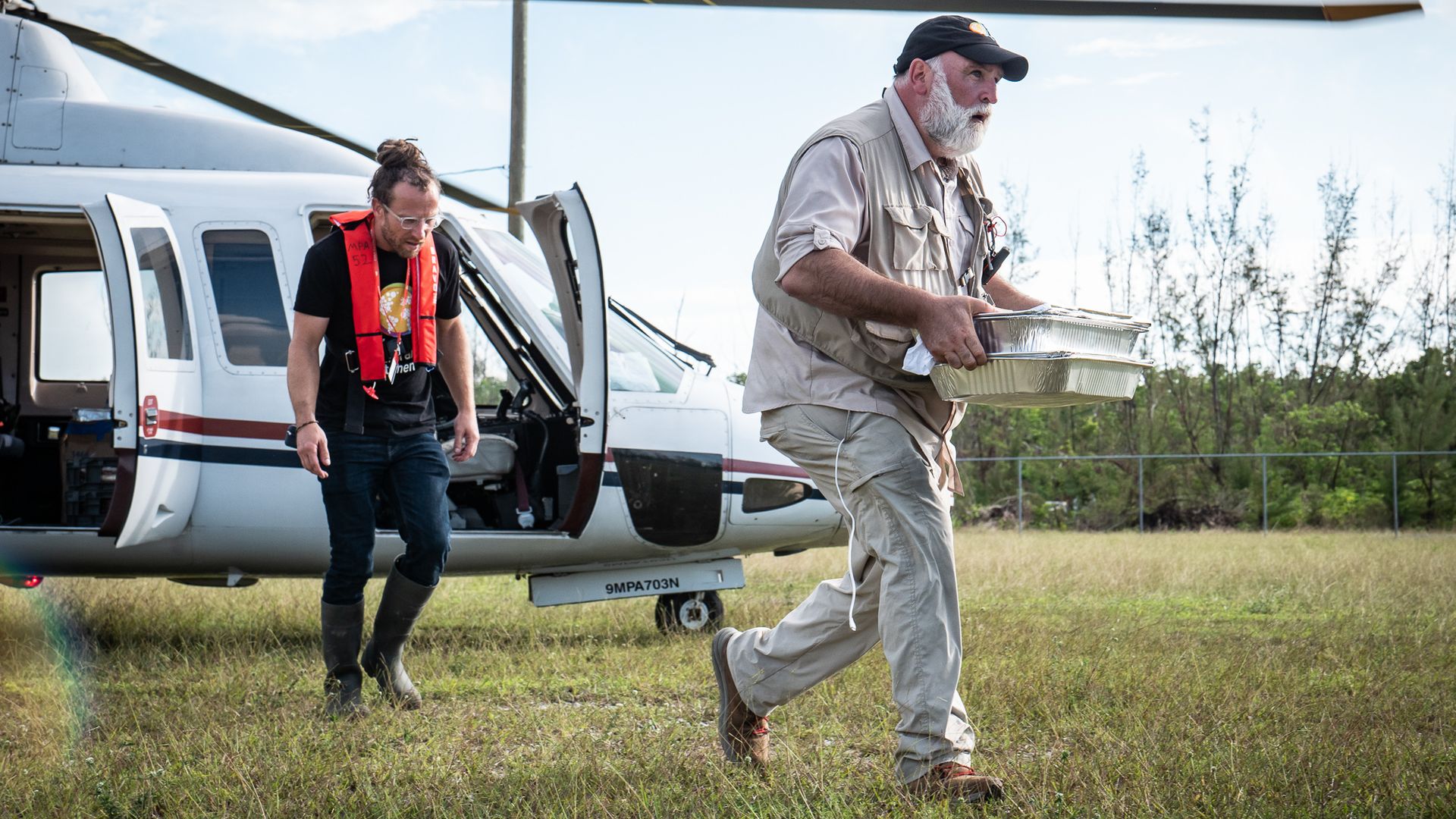 A man runs carrying trays of food.