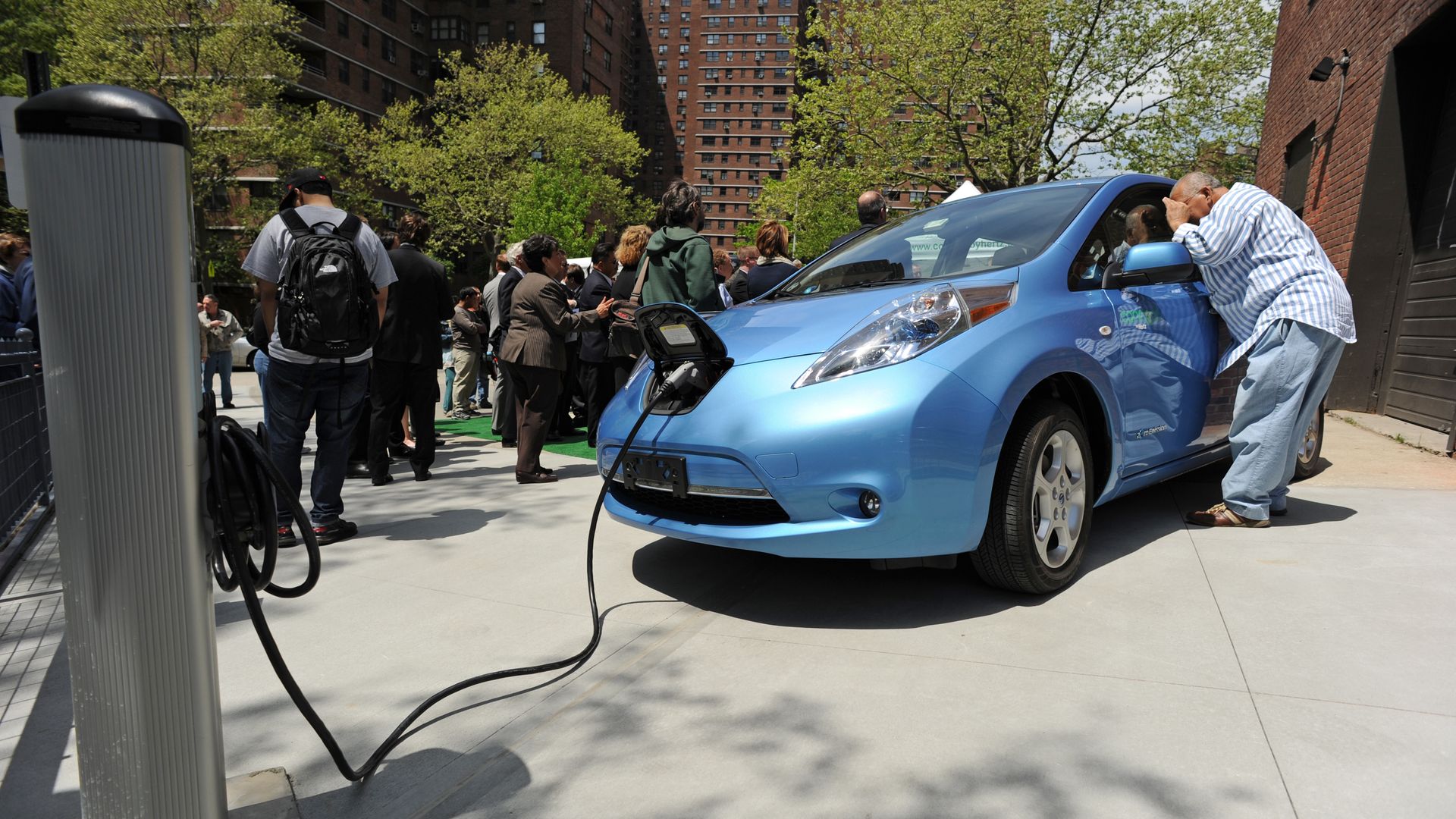A man looks into a Nissan Leaf electric car t on the Lower East Side of Manhattan May 6, 2011 in New York.