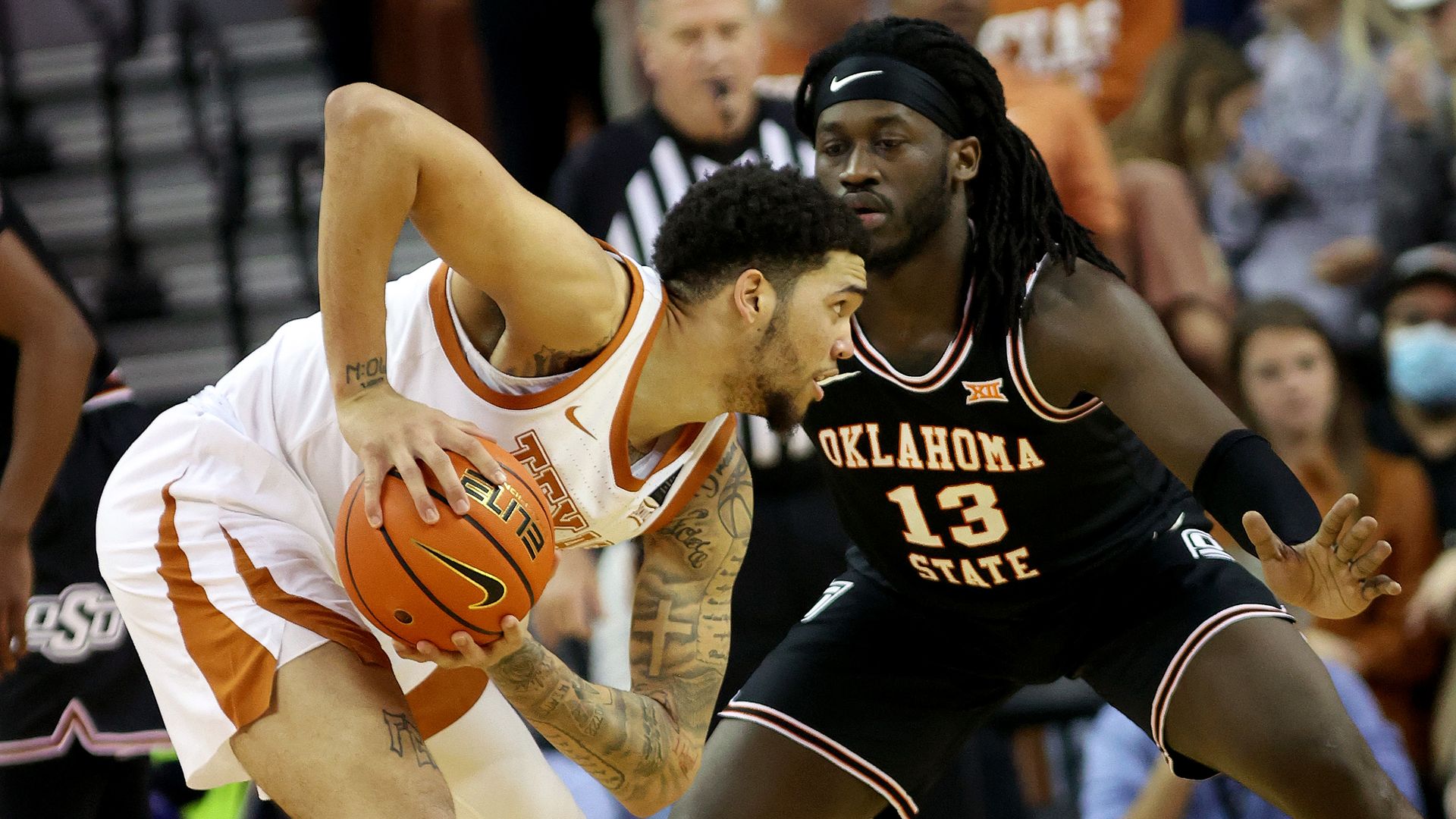 Timmy Allen #0 of the Texas Longhorns holds the ball in front of Isaac Likekele #13 of the Oklahoma State Cowboys at the Frank Erwin Center.